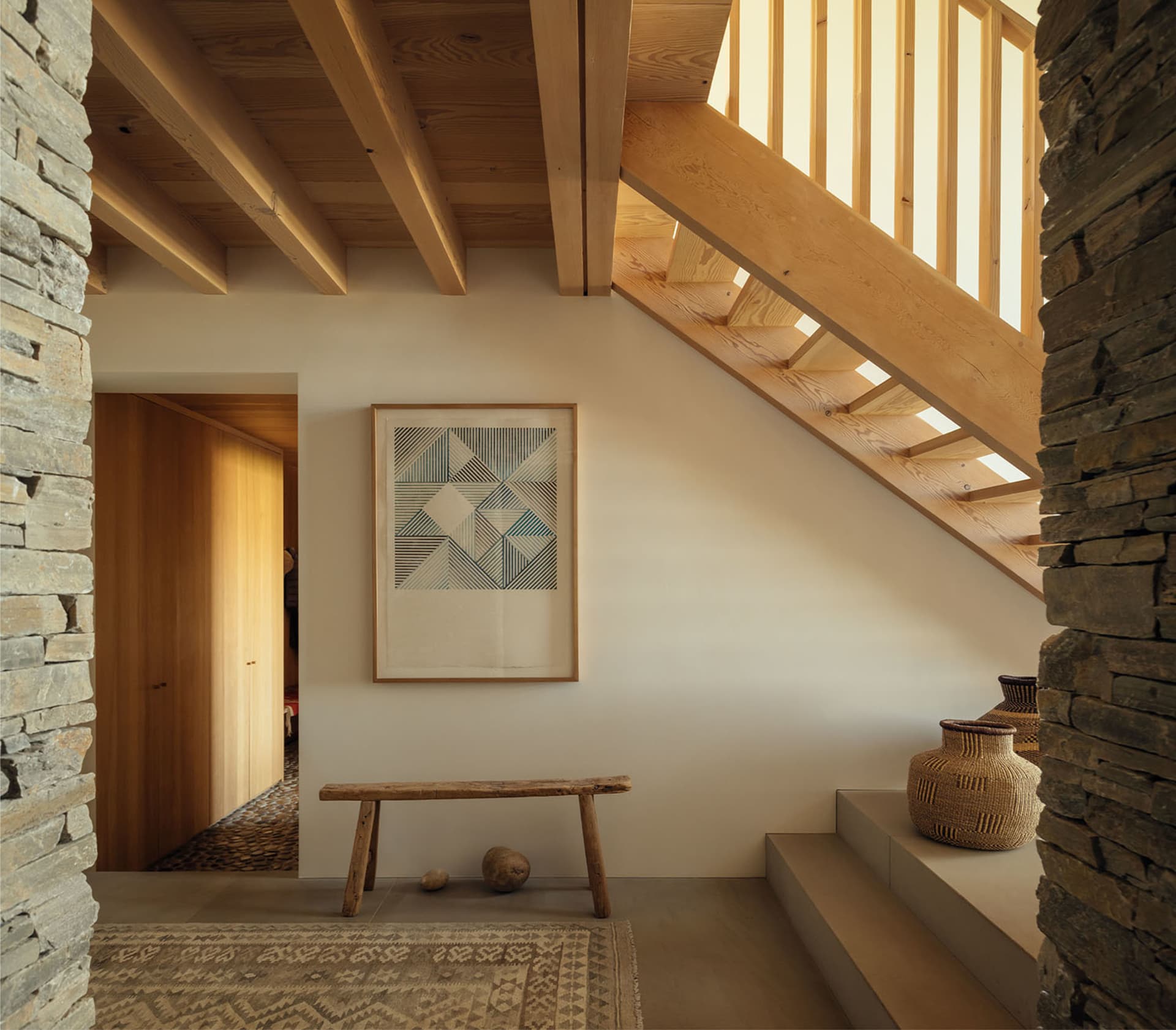 A modern staircase with wooden stairs, a wooden bench, and a geometric art piece.
