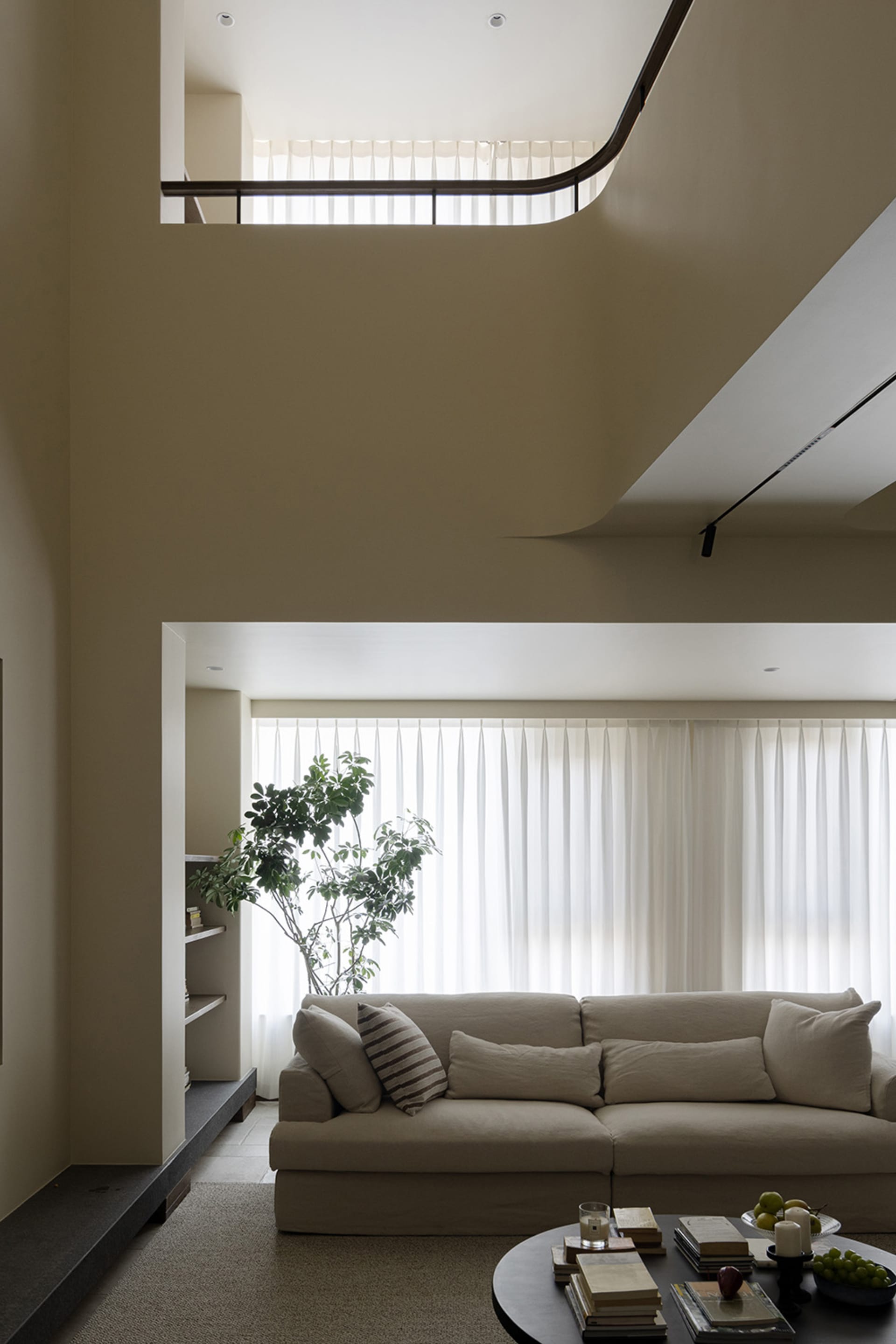 A modern living room featuring a comfortable fabric sofa with a minimalist design, natural light streaming in through large w