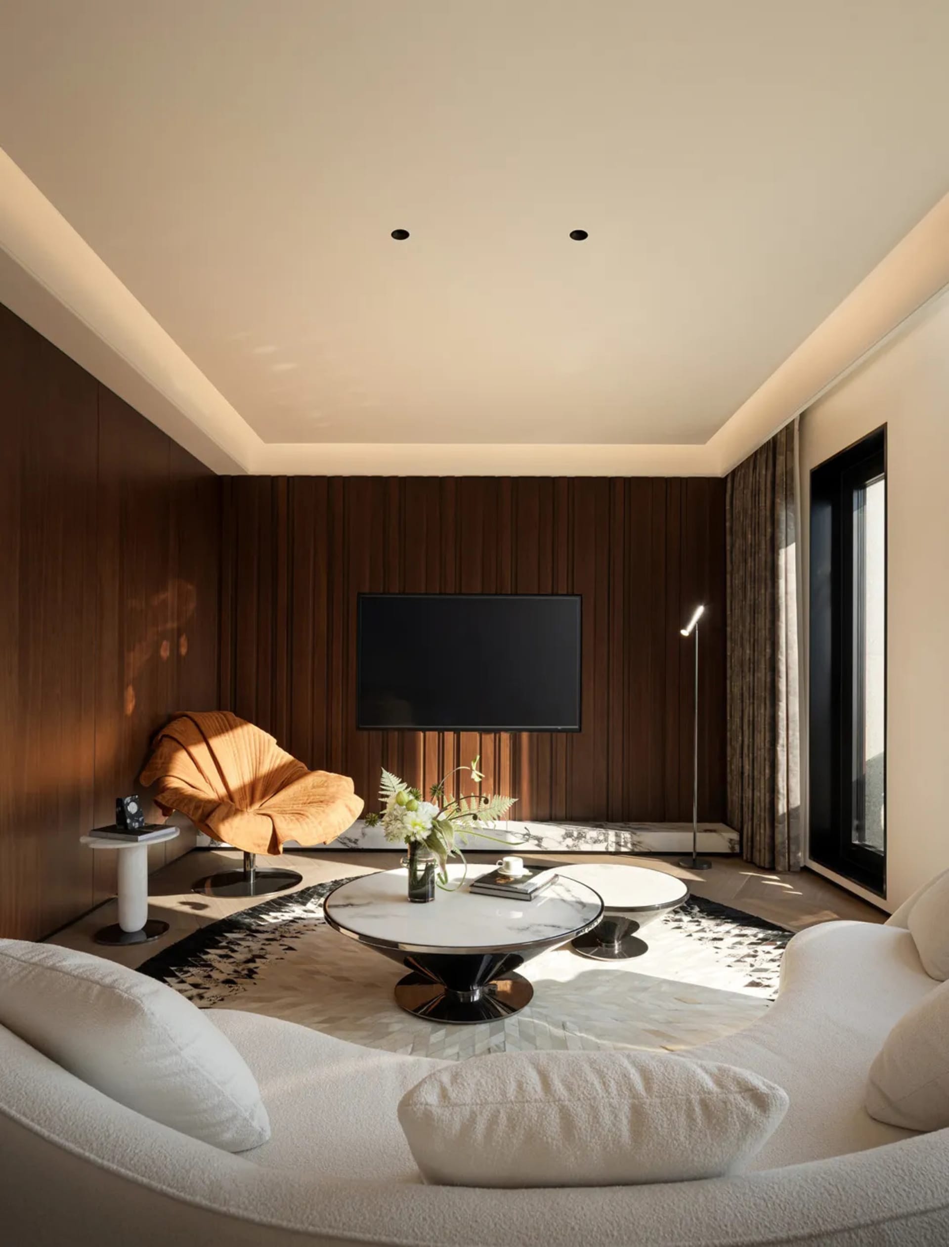 Modern living room featuring marble, wood, and metal materials.