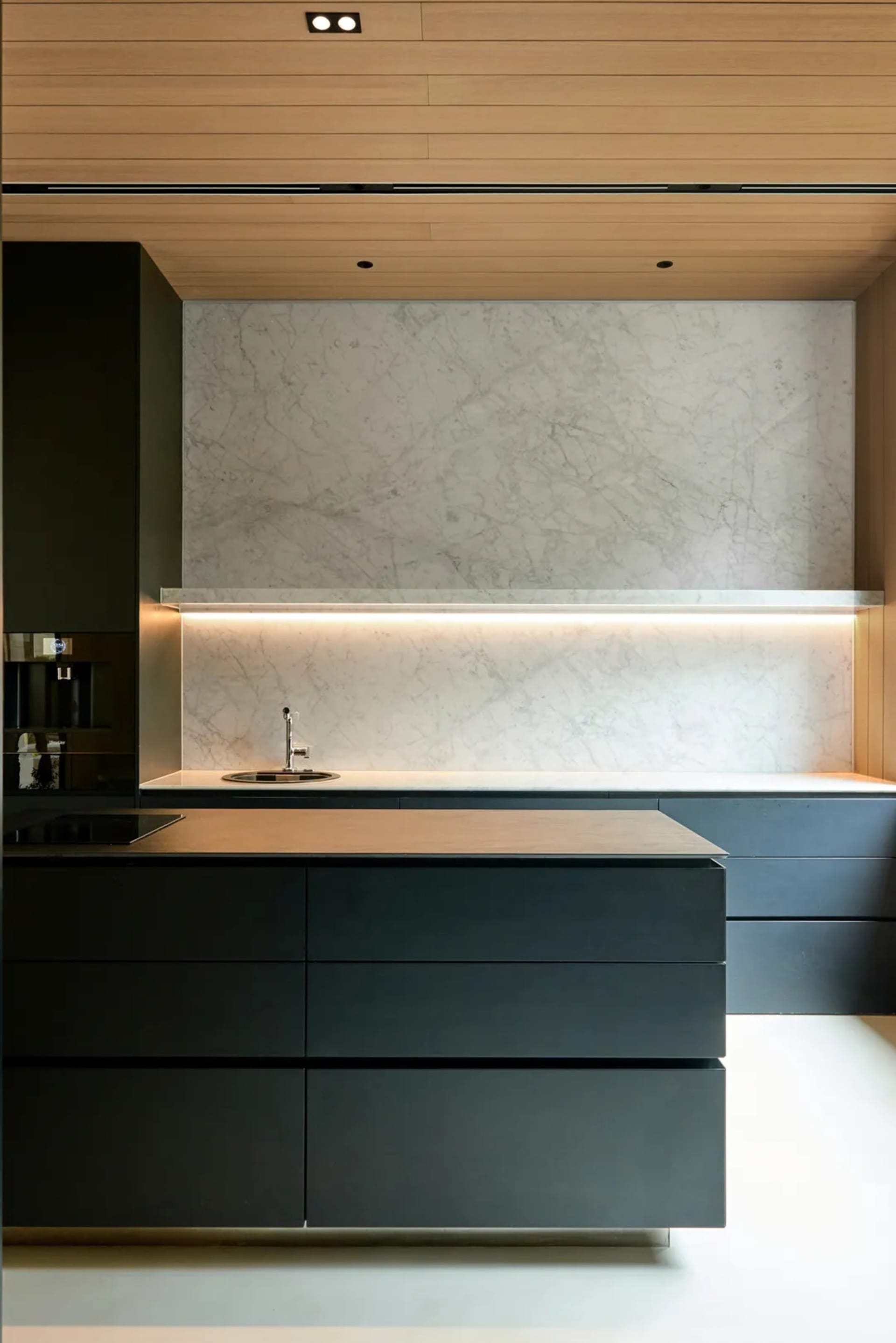 Modern minimalist kitchen with marble countertop and stainless steel appliances