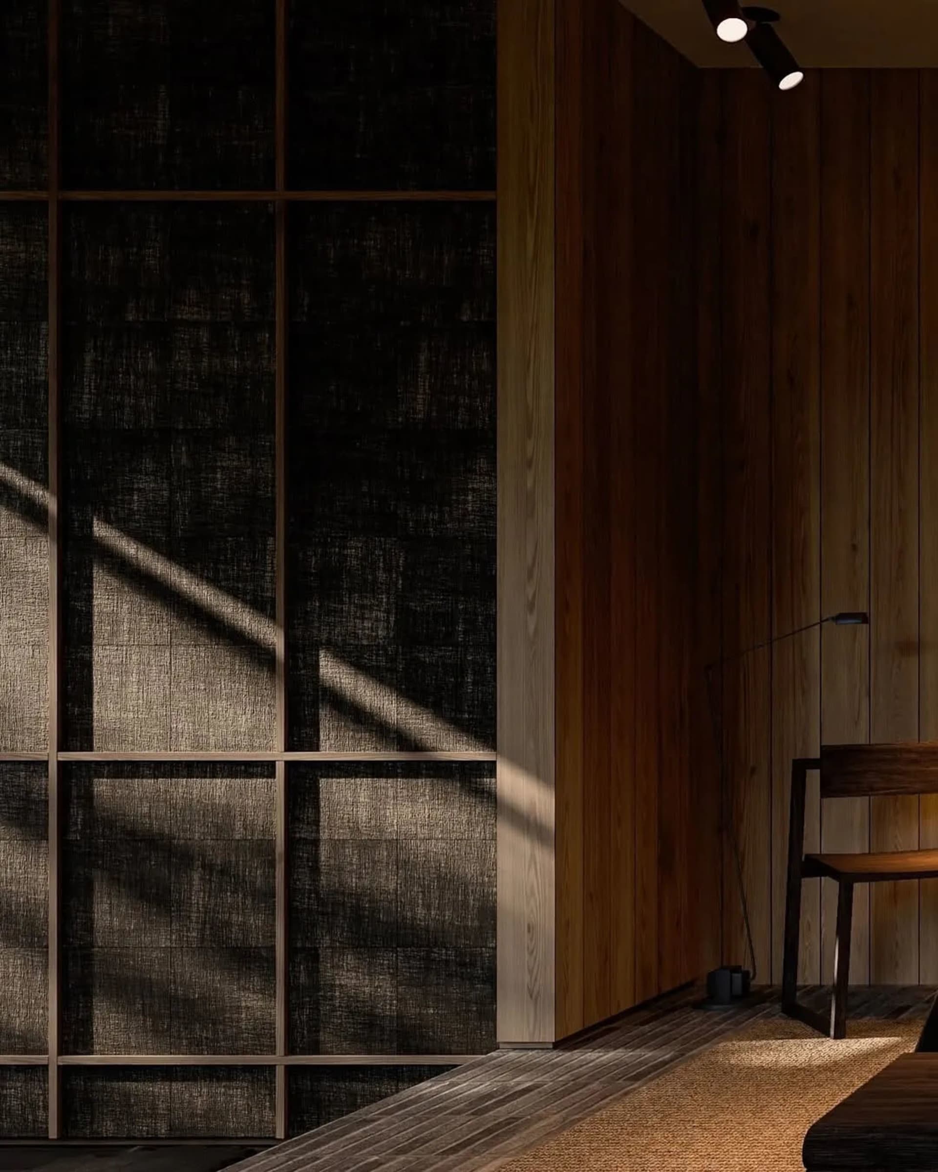 A minimalist bedroom featuring wooden paneling and a light wooden chair.