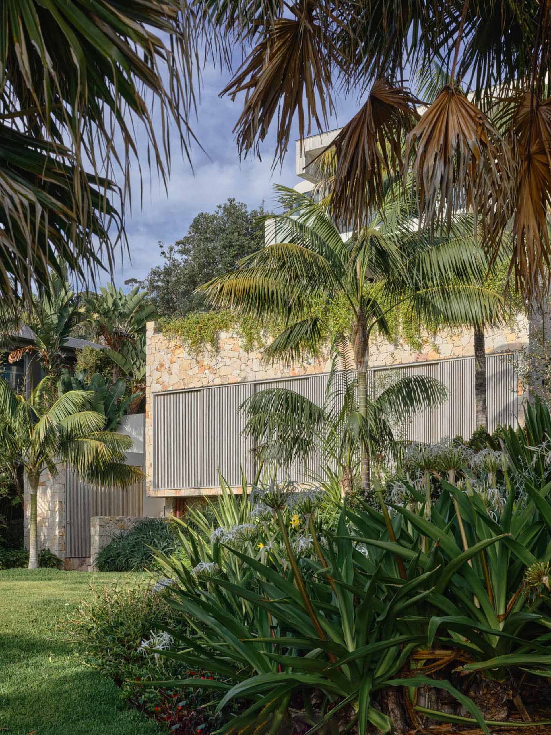 Modern residential exterior with stone walls and metal accents.