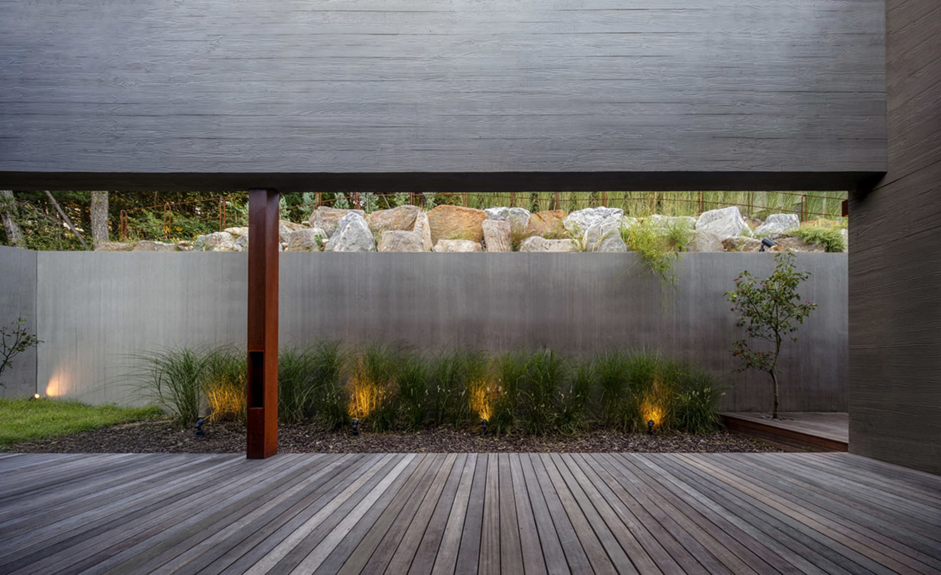 A modern outdoor garden featuring concrete walls and landscaping.