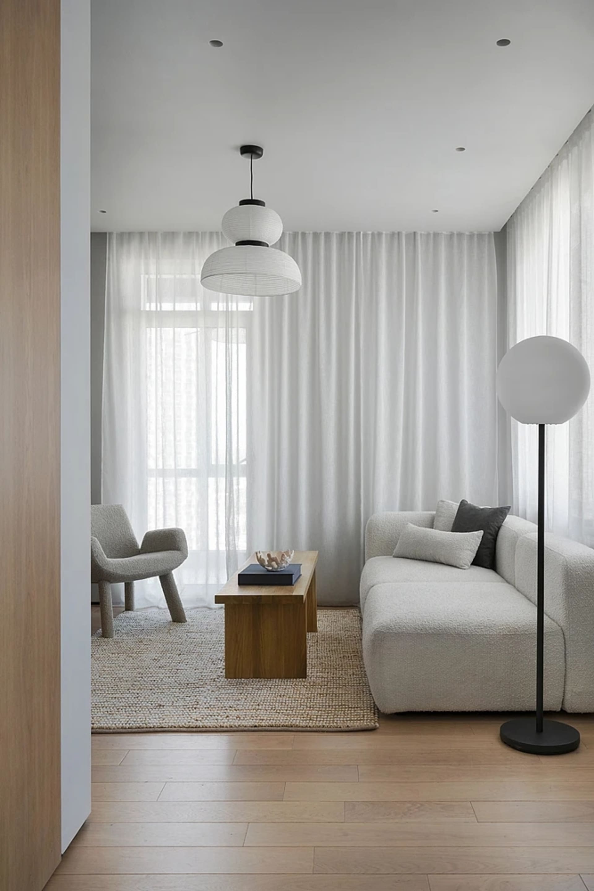 Modern living room with fabric furniture, wooden coffee table, glass pendants