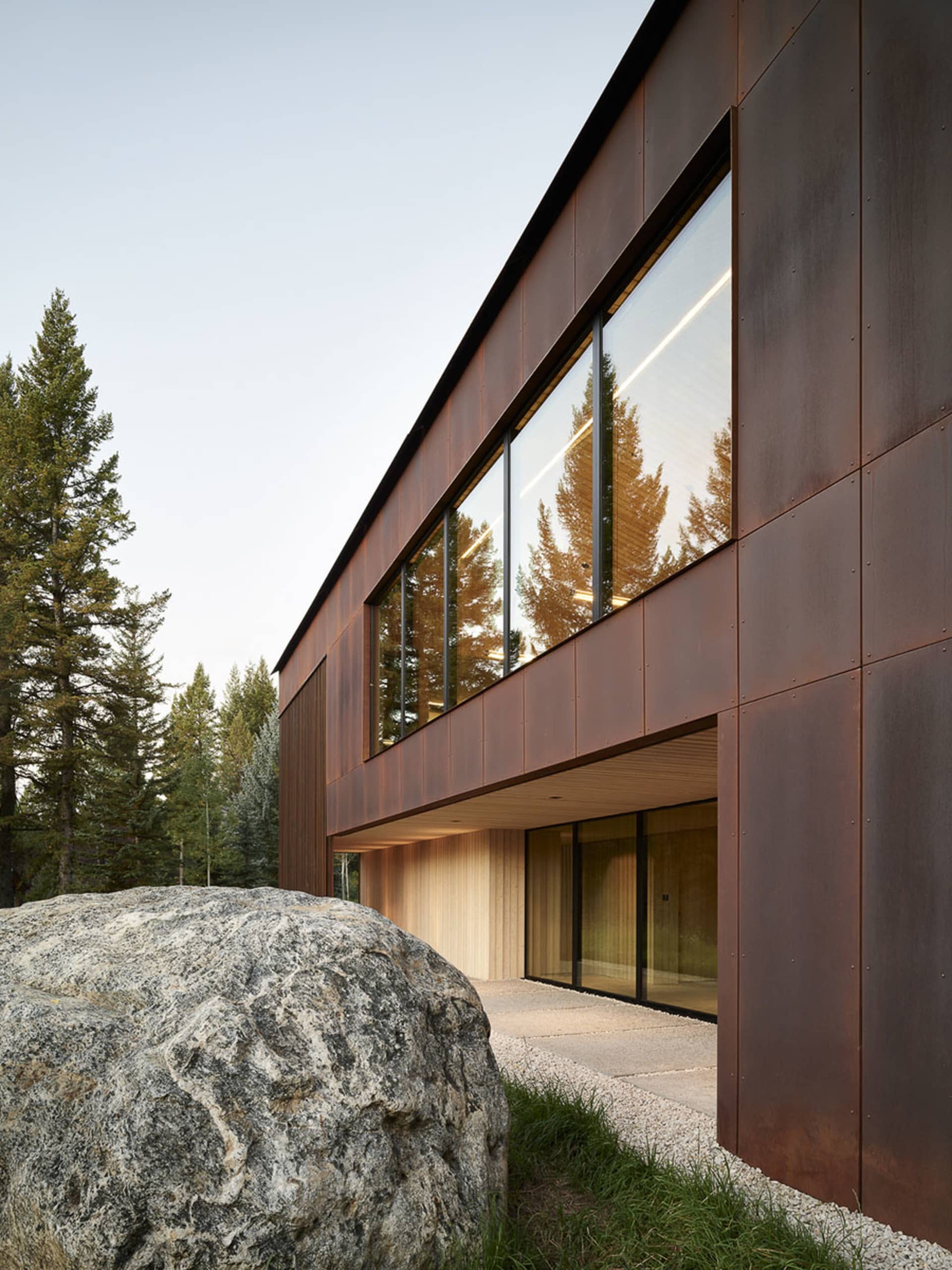 Modern residential exterior featuring metal cladding and large windows.