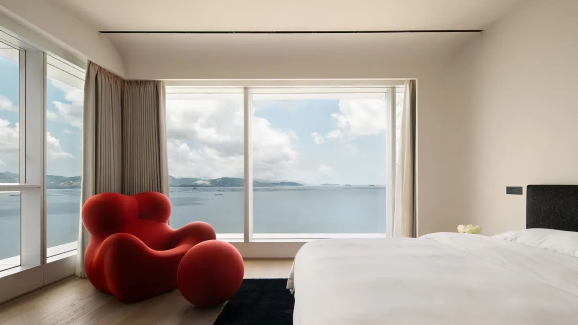 簡約臥室配有玻璃窗，可眺望海洋景色。