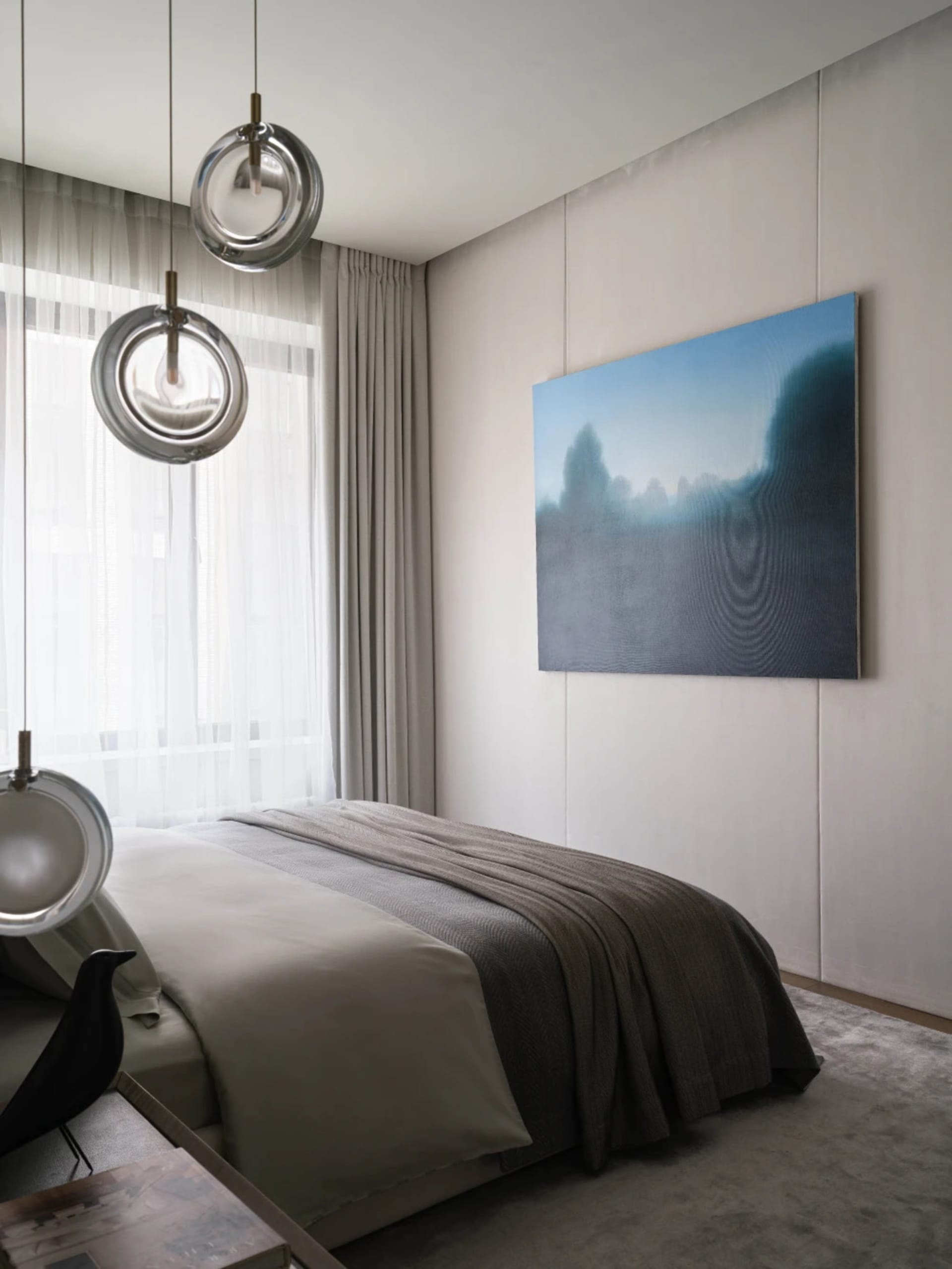 Modern minimalist bedroom with grey walls, grey bedspread, and circular glass light fixtures.