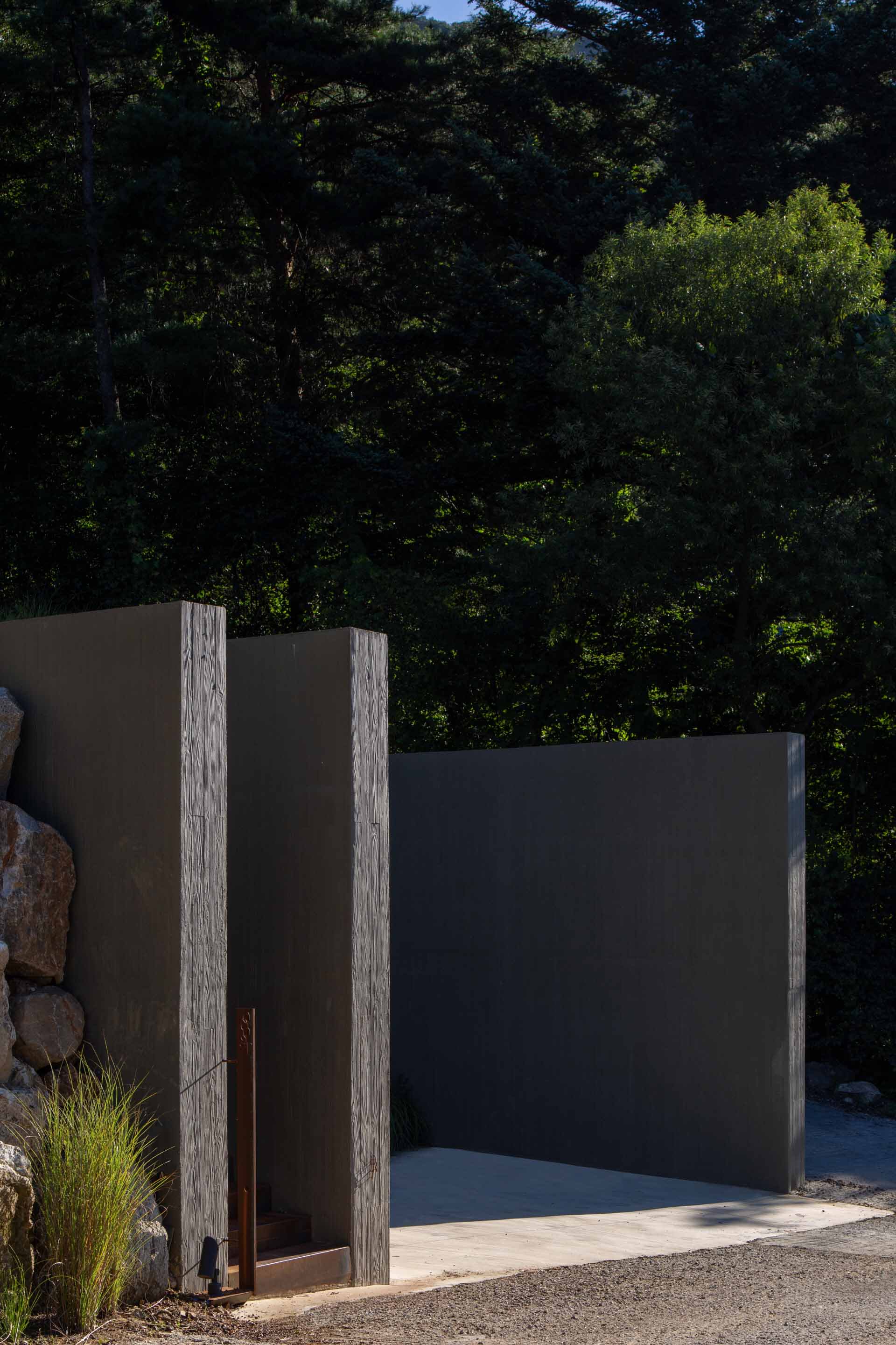 Modern architectural entrance featuring metal cladding and concrete materials.