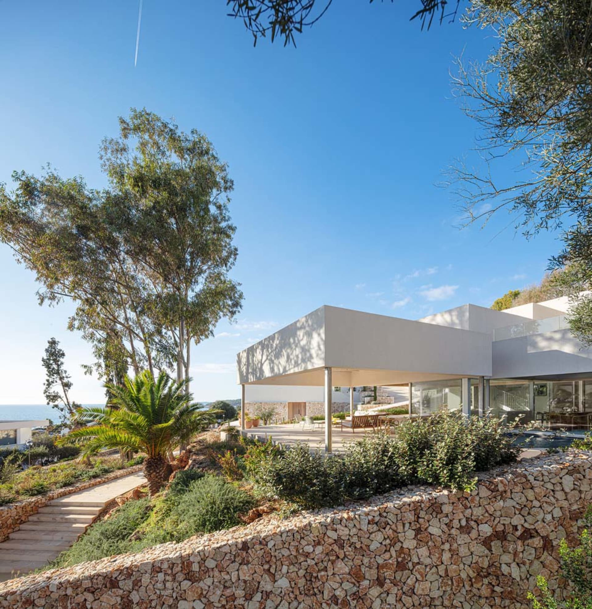 A modern residential exterior featuring concrete and glass materials.