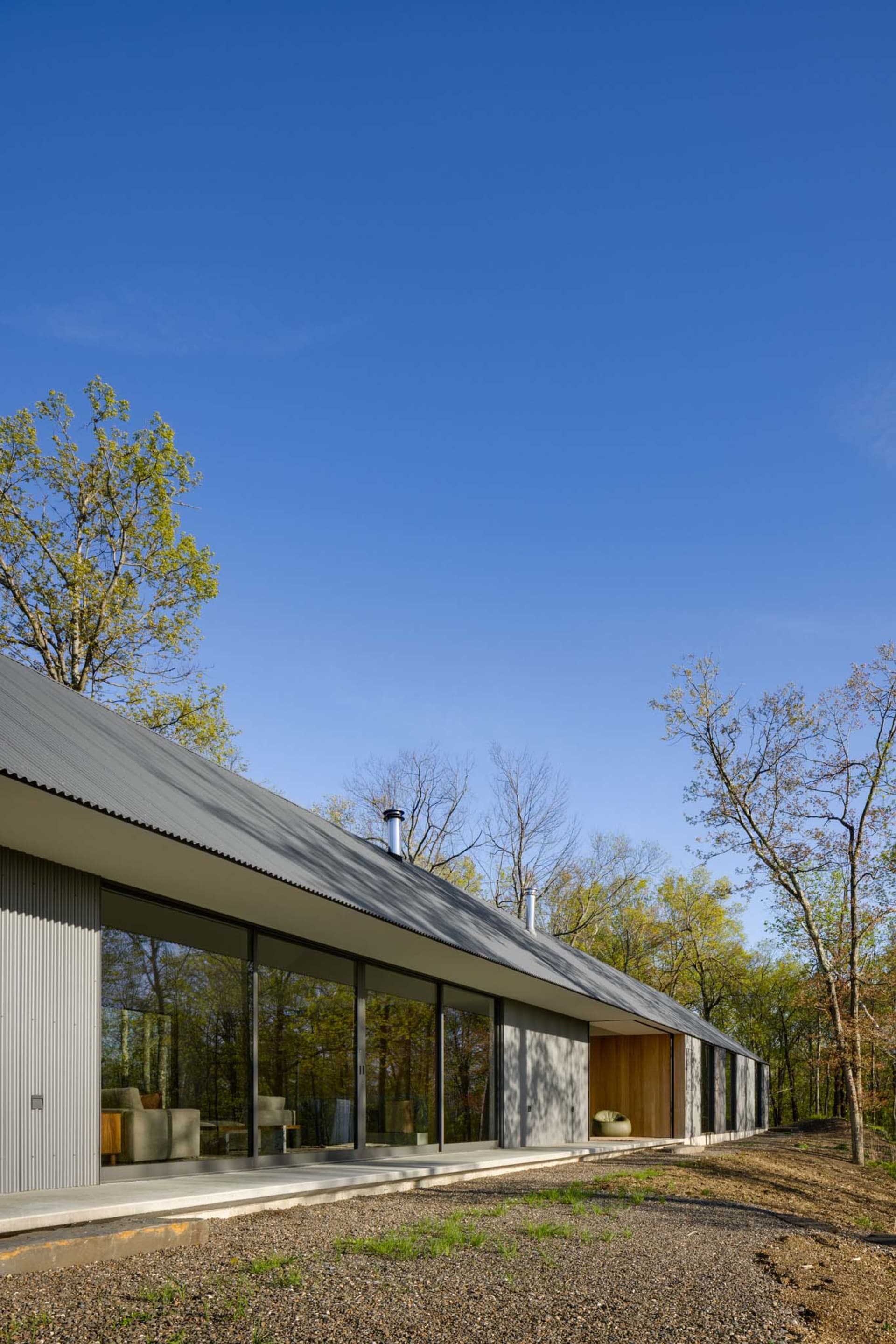 Modern minimalist metal building with large windows and a flat roof.
