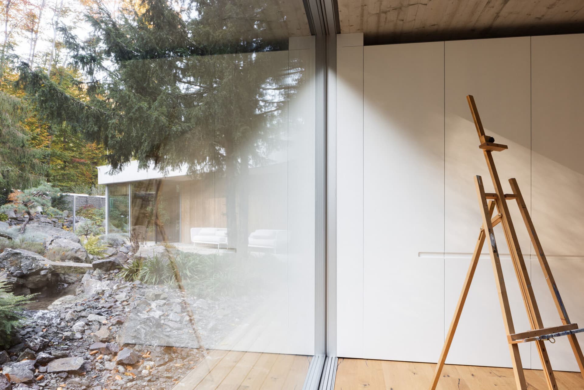 Minimalist interior design with large glass doors and modern furniture in a Brutalist style.