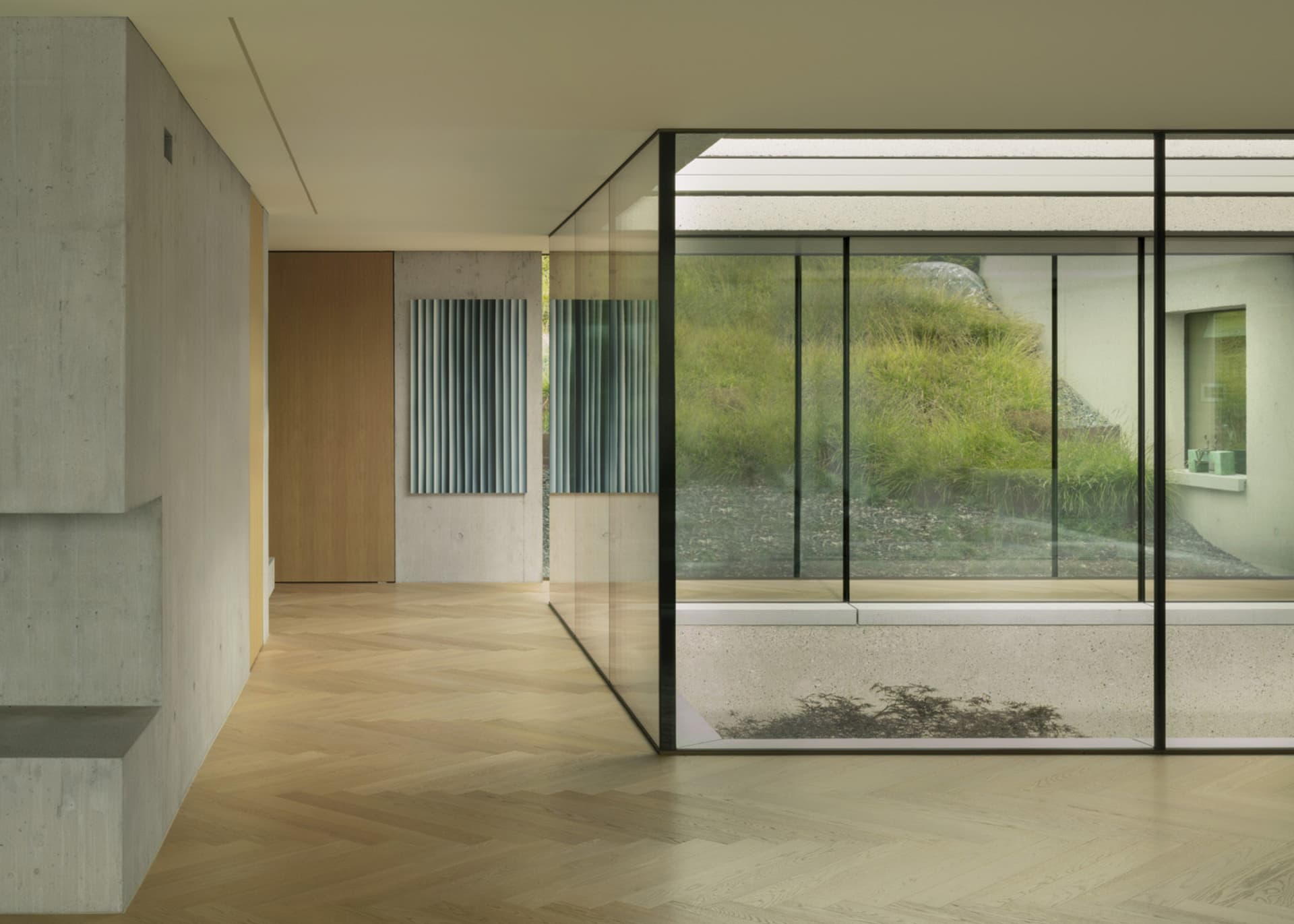 Modern living room featuring concrete walls, glass windows, and wooden flooring