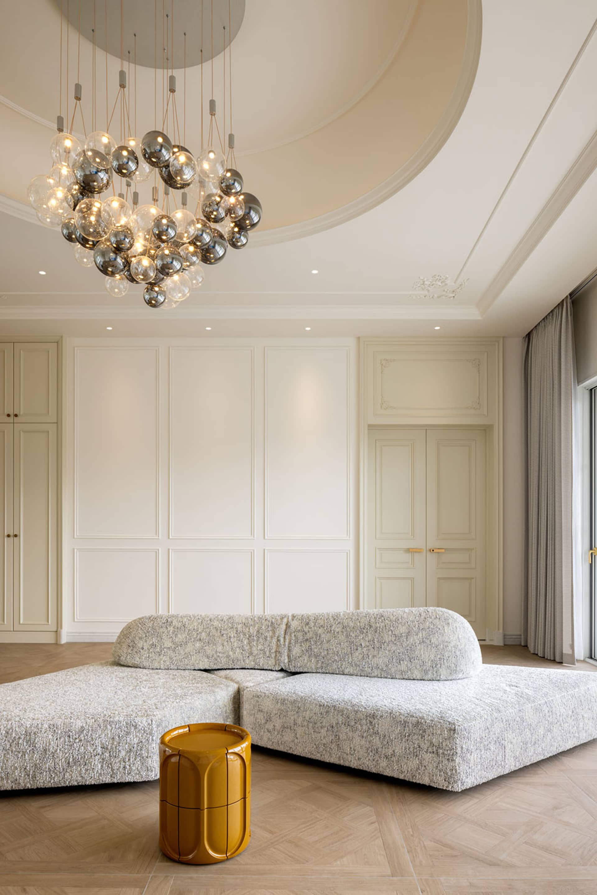 A modern living room with a fabric sofa and a yellow side table.