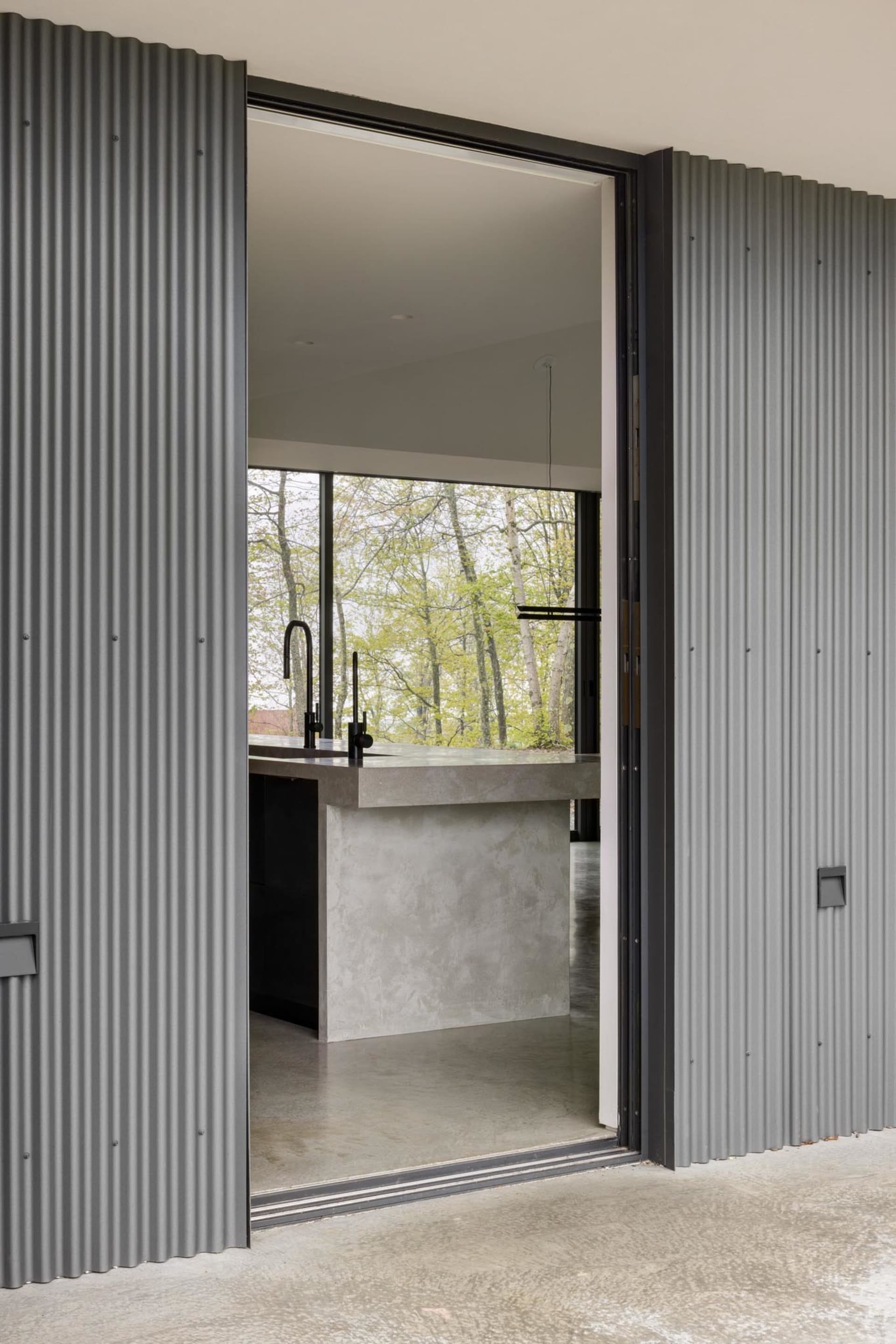 Modern minimalist kitchen with metal cabinets and concrete countertops