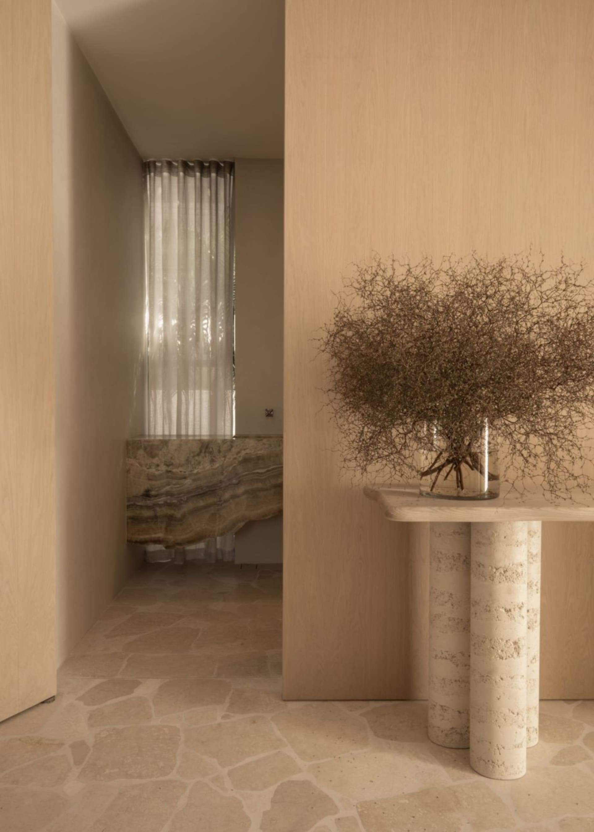 A modern bathroom with marble walls and floor, featuring a bathtub and a curtain.