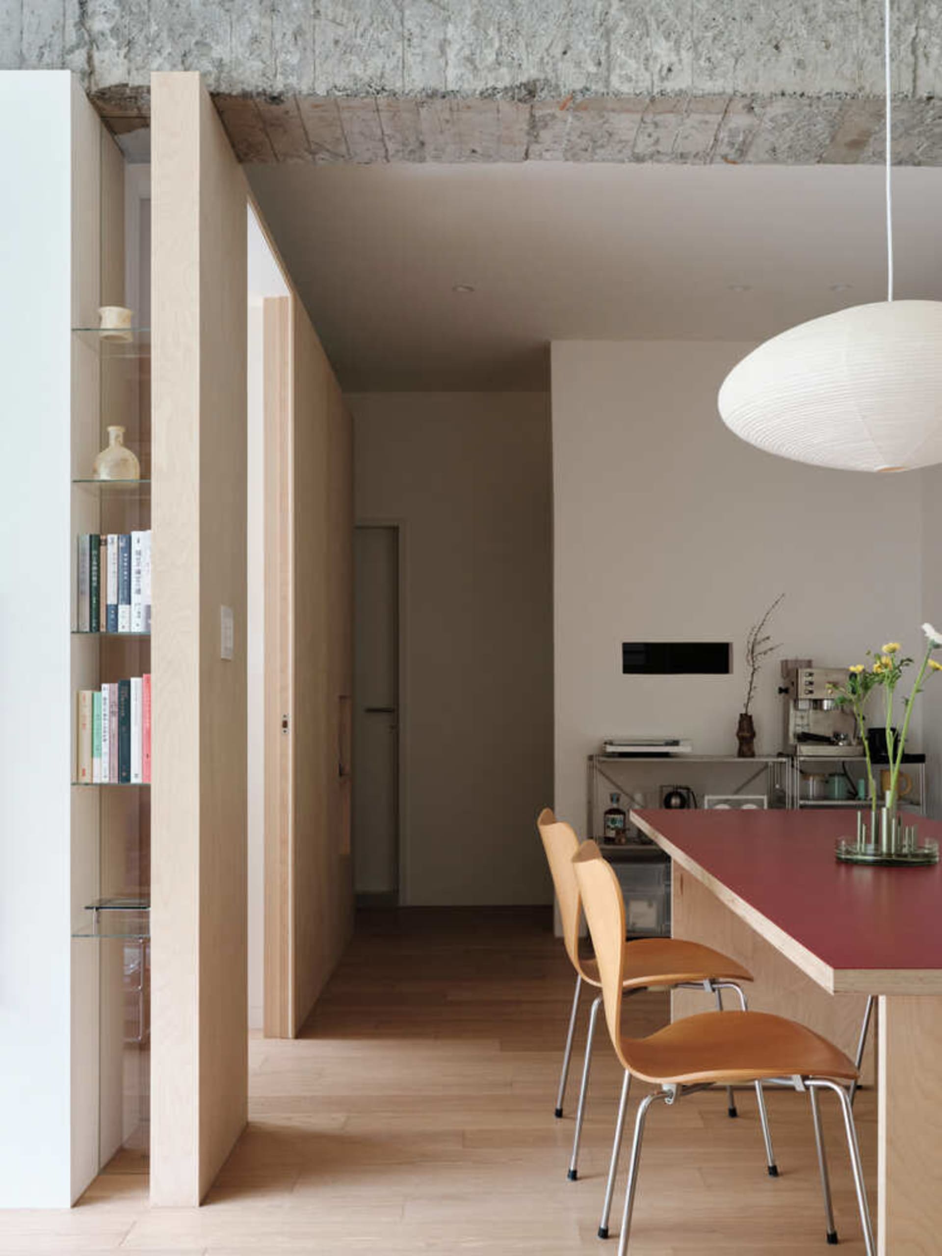 Modern minimalist kitchen dining space featuring wood, concrete, and metal materials.