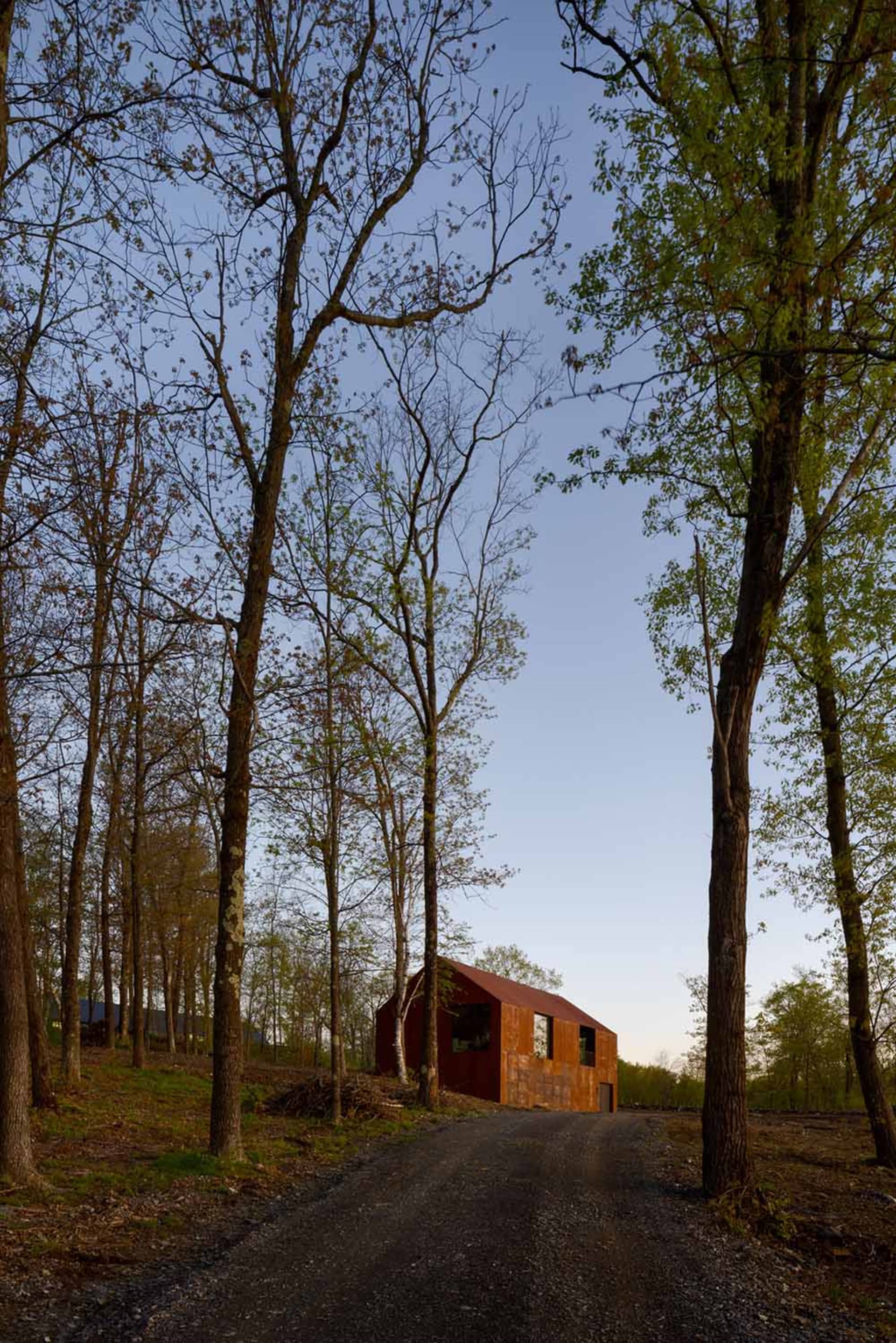 Rustic house with a red exterior surrounded by trees