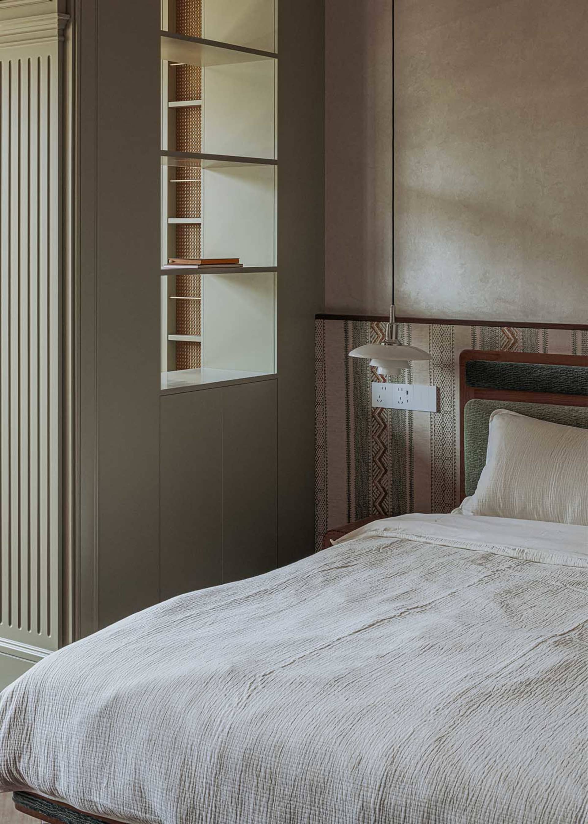 A contemporary bedroom featuring a bed with textile bedding and a modern design.