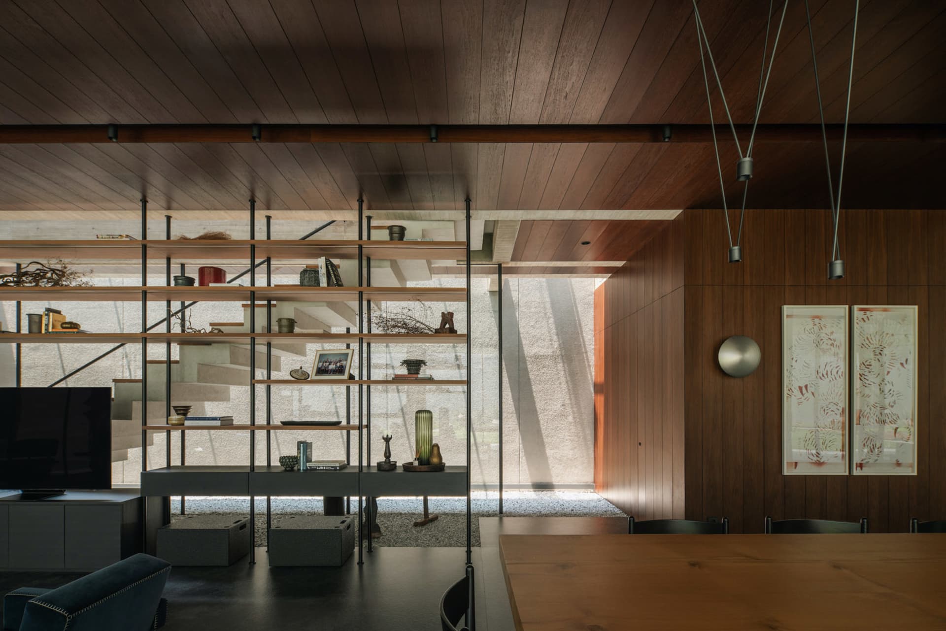 A modern dining room featuring wooden shelving with various decorative items.