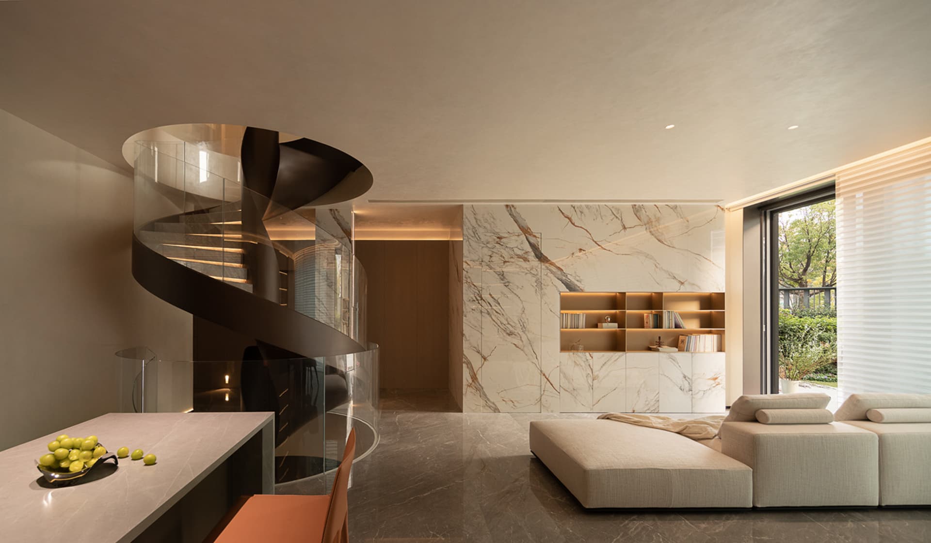 Modern residential space featuring a luxurious marble kitchen counter with a spiral staircase and a contemporary white sofa.