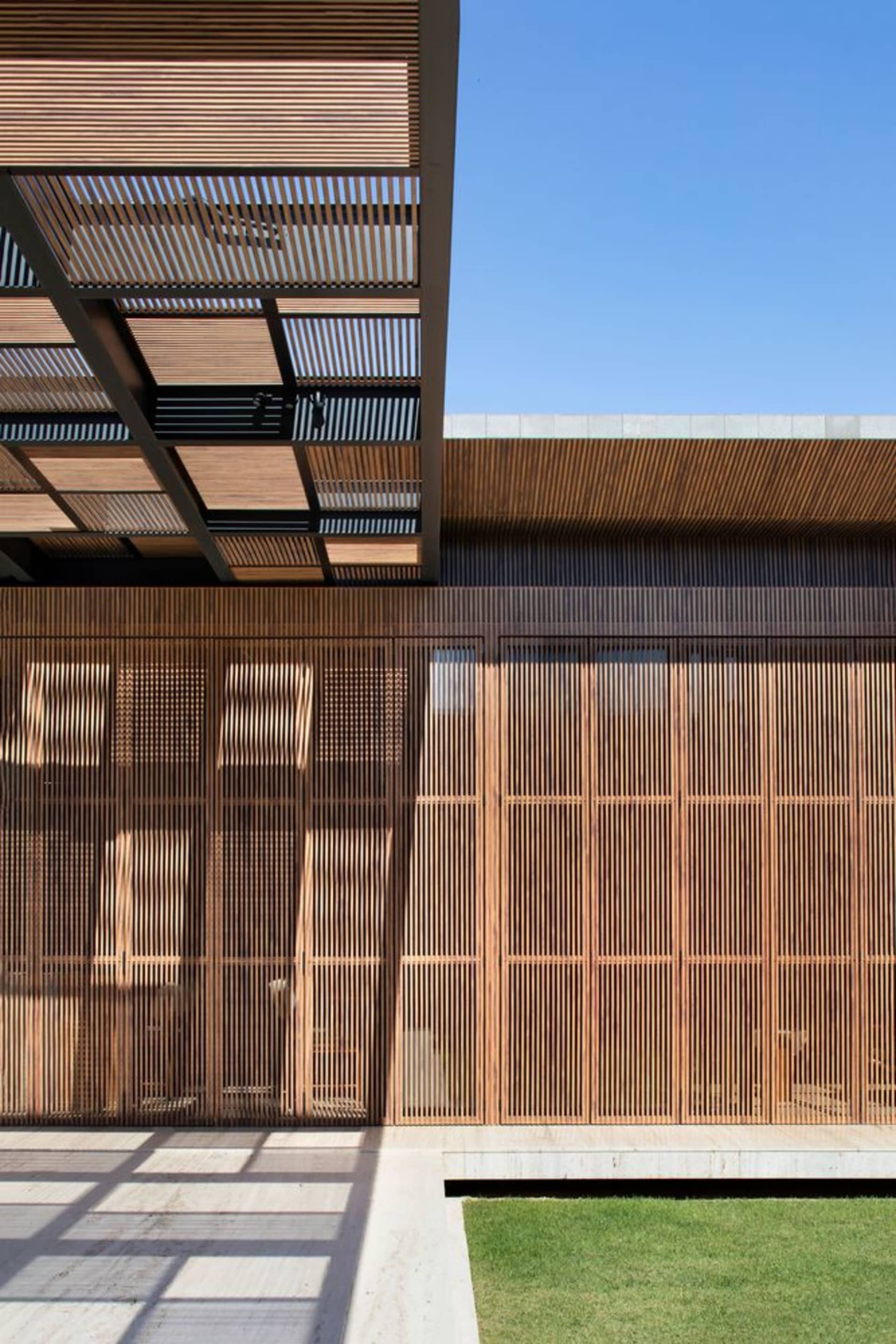 Modern architectural exterior featuring wooden slat walls and an open patio area.