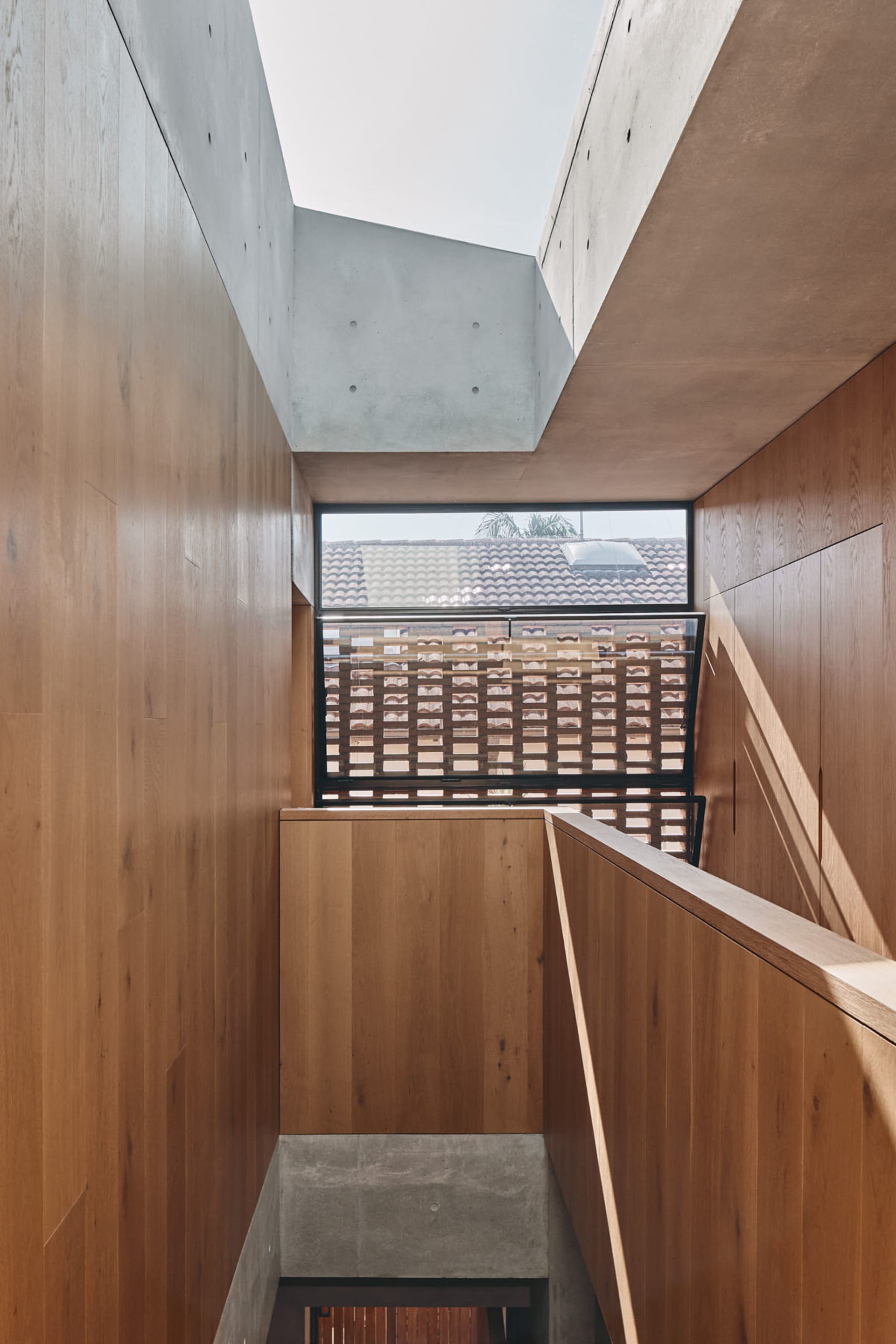 A modern interior design featuring wooden walls and concrete structural elements.