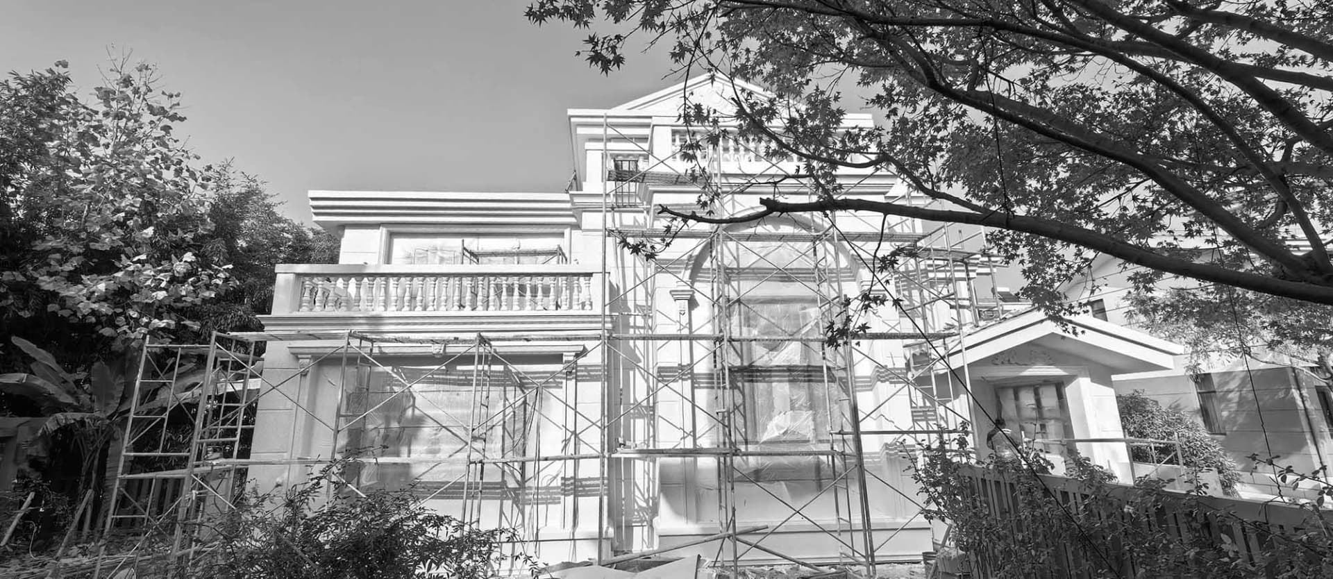 House undergoing renovation with metal scaffolding in front of it.