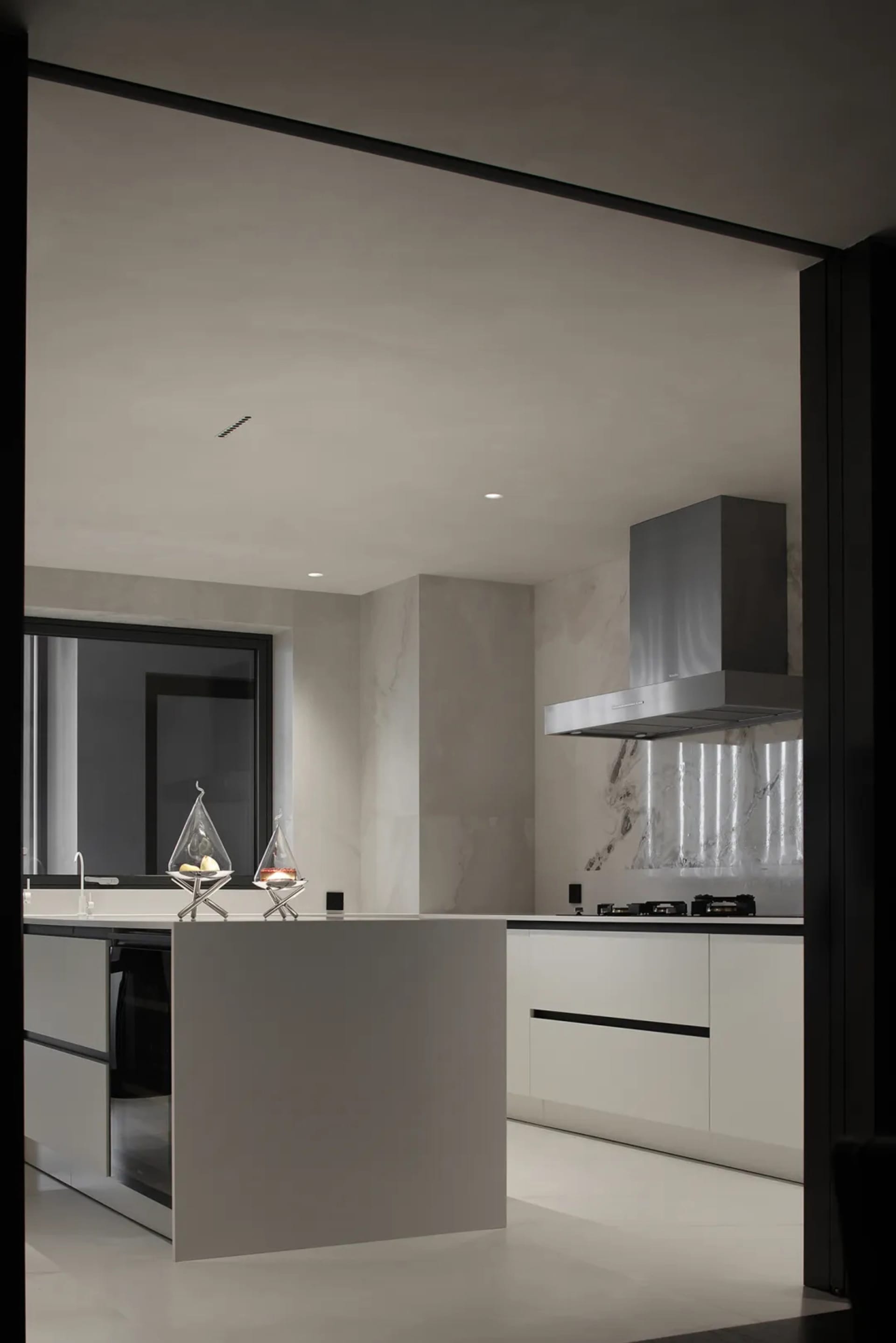 A modern kitchen with marble countertops and stainless steel appliances.