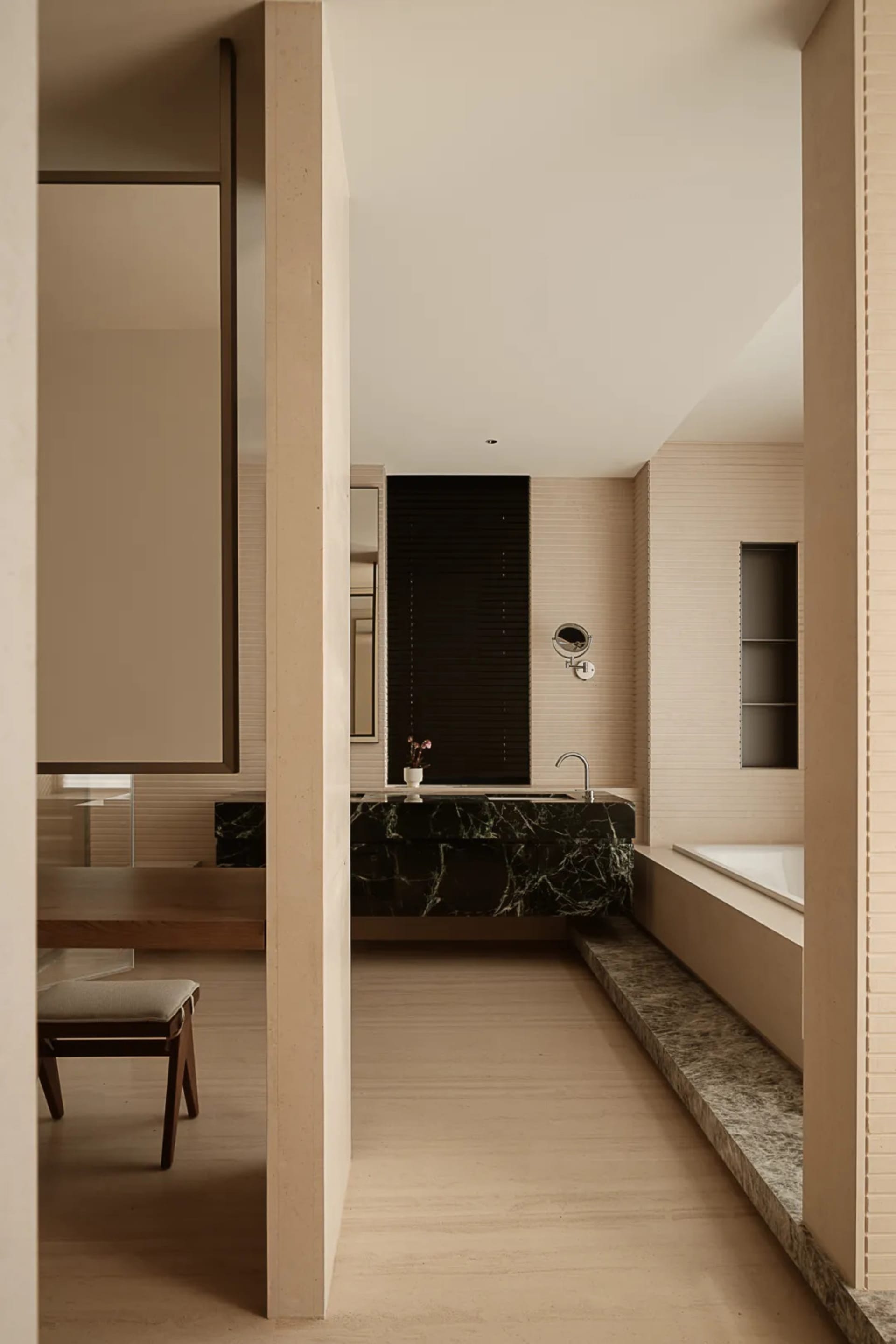 Modern minimalist bathroom with marble finishes and black accents.