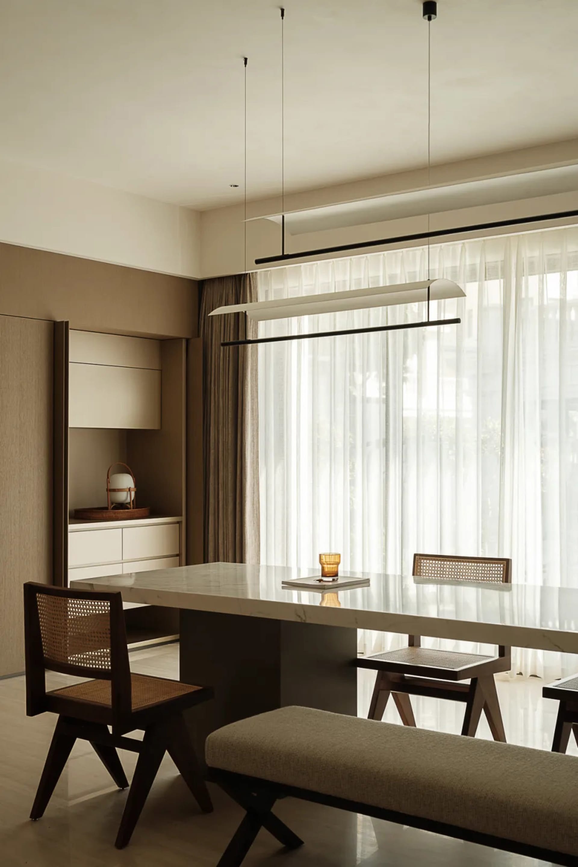 Modern residential dining room featuring a sleek marble tabletop with minimalist design.