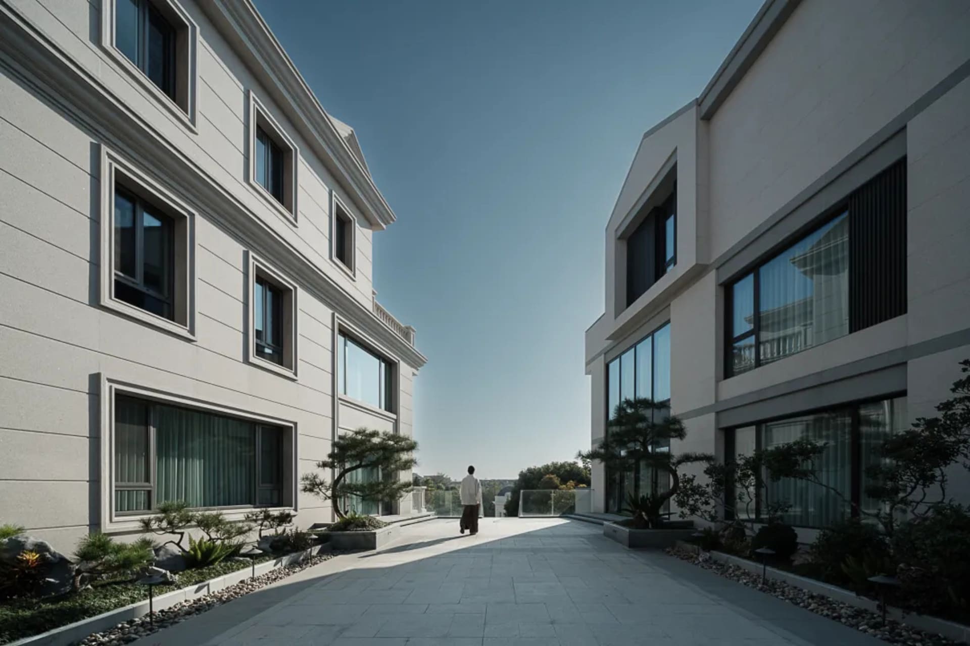Modern exterior view of a building with concrete, glass, and stone materials.