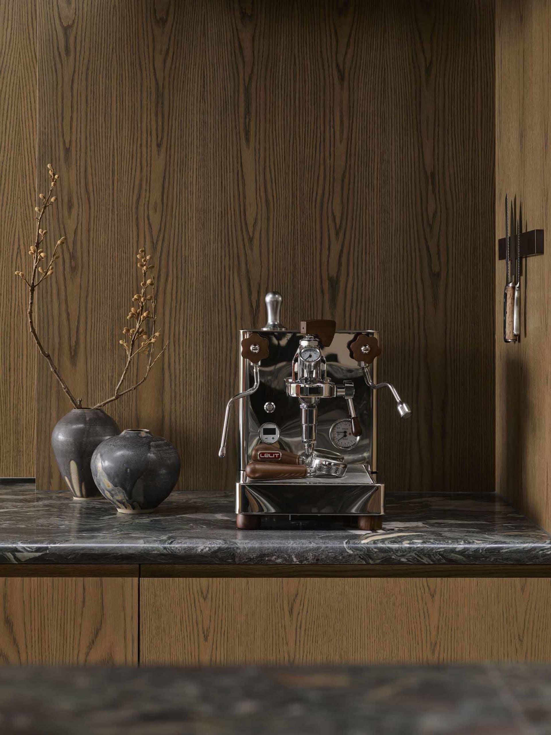 A sleek, modern kitchen featuring metallic appliances, wooden accents, and marble countertops.