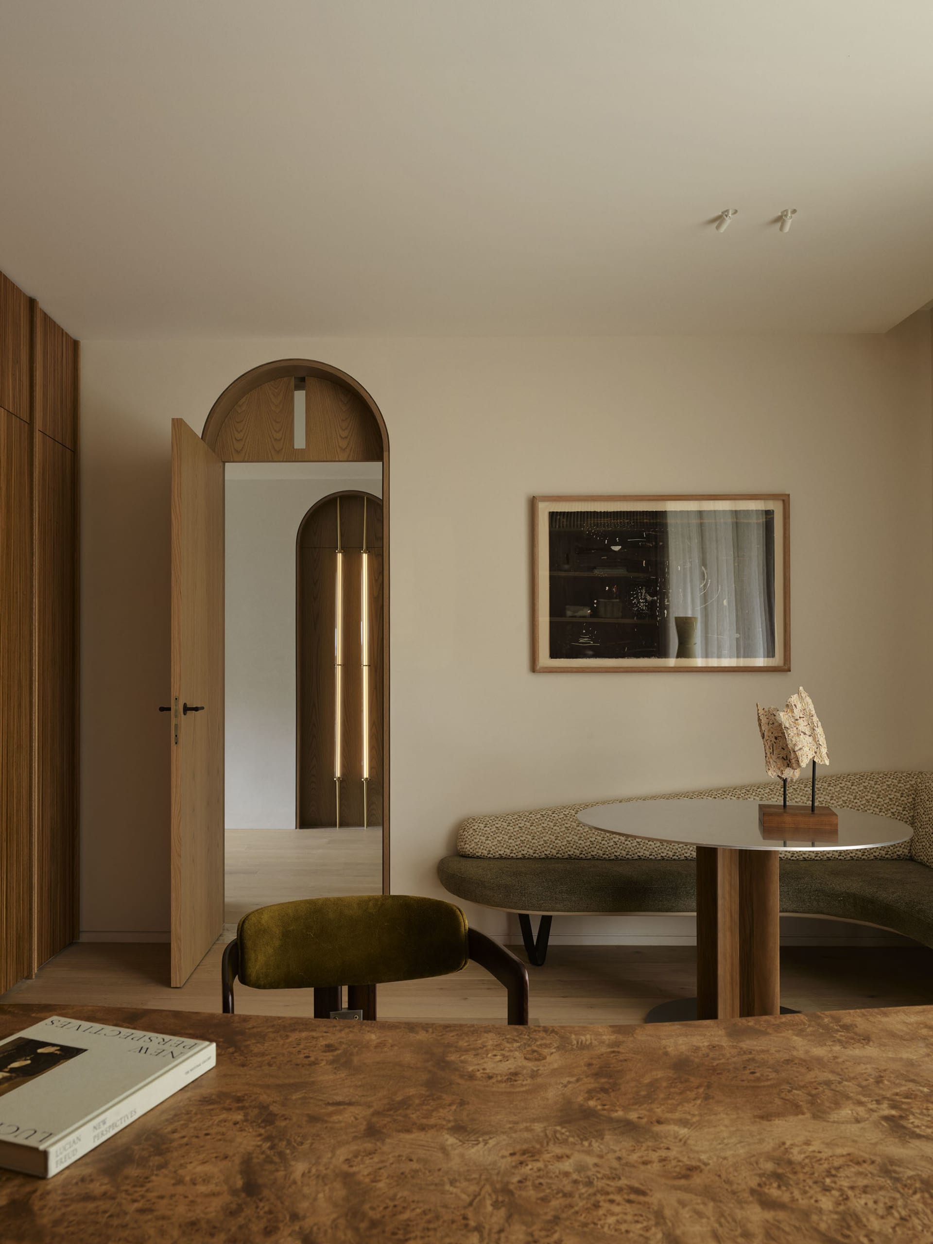 A modern living room featuring melamine veneer furniture and a round dining table with a reflective surface.