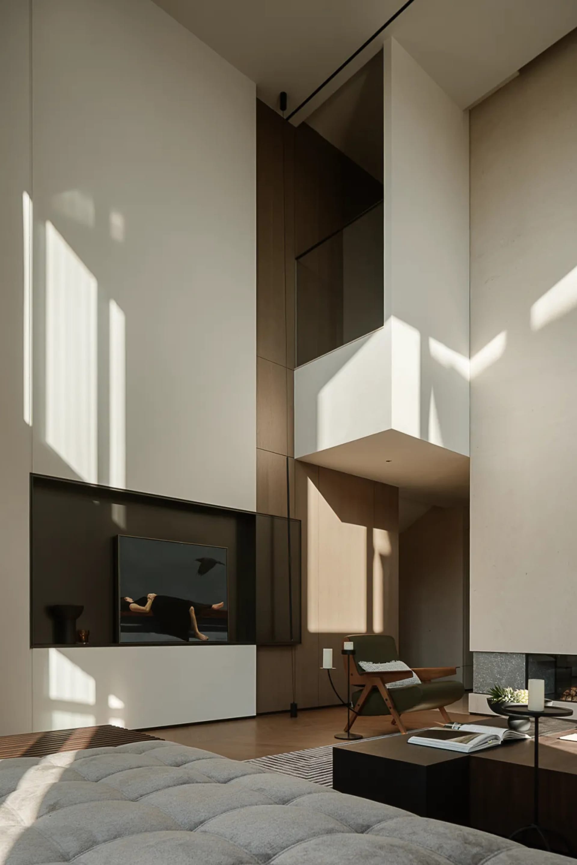 A modern living room with concrete walls, wooden furniture, and glass elements.