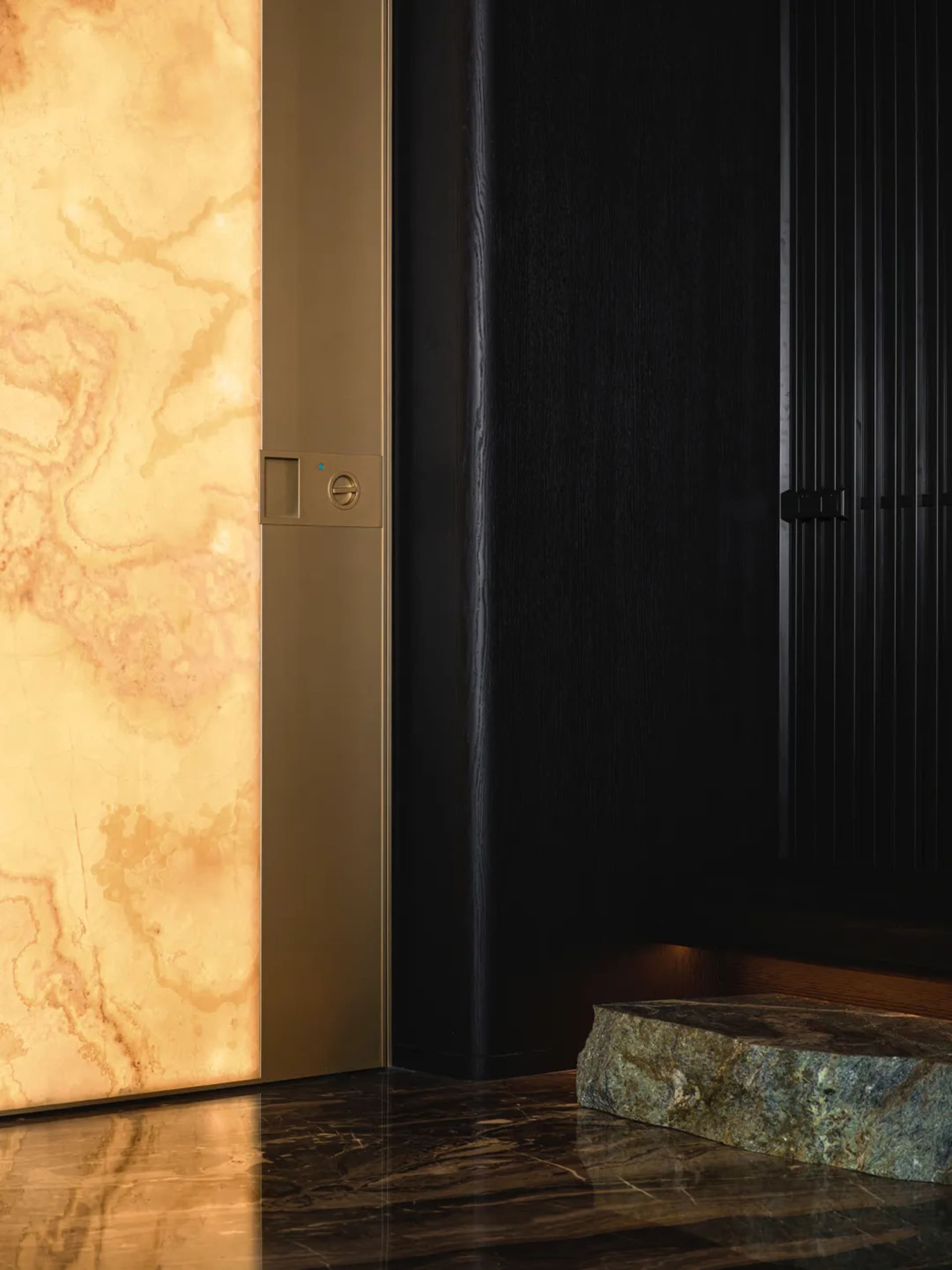 An elegant modern entrance hall with marble flooring and a textured wall.