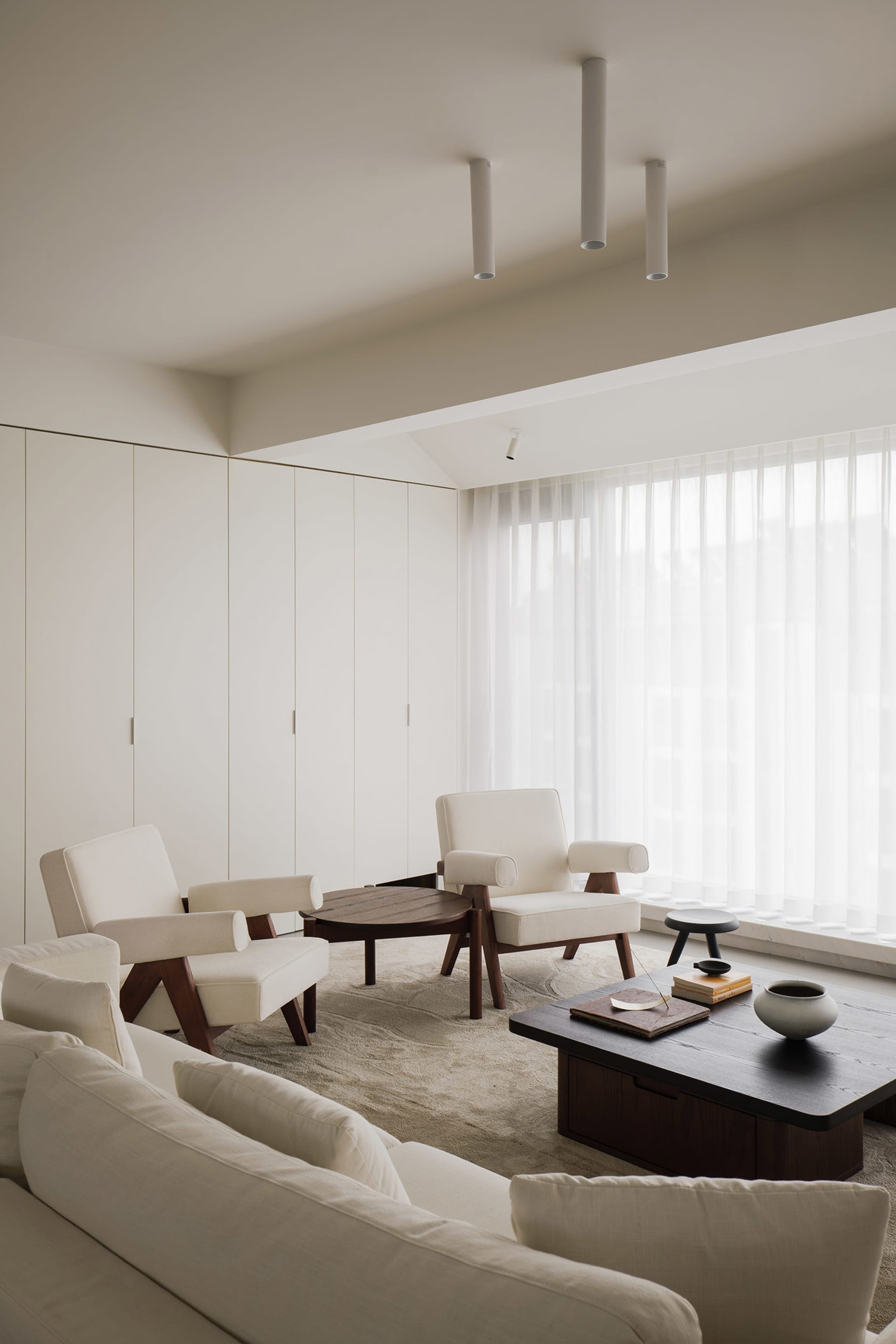 A modern living room with neutral-colored furniture and decor.