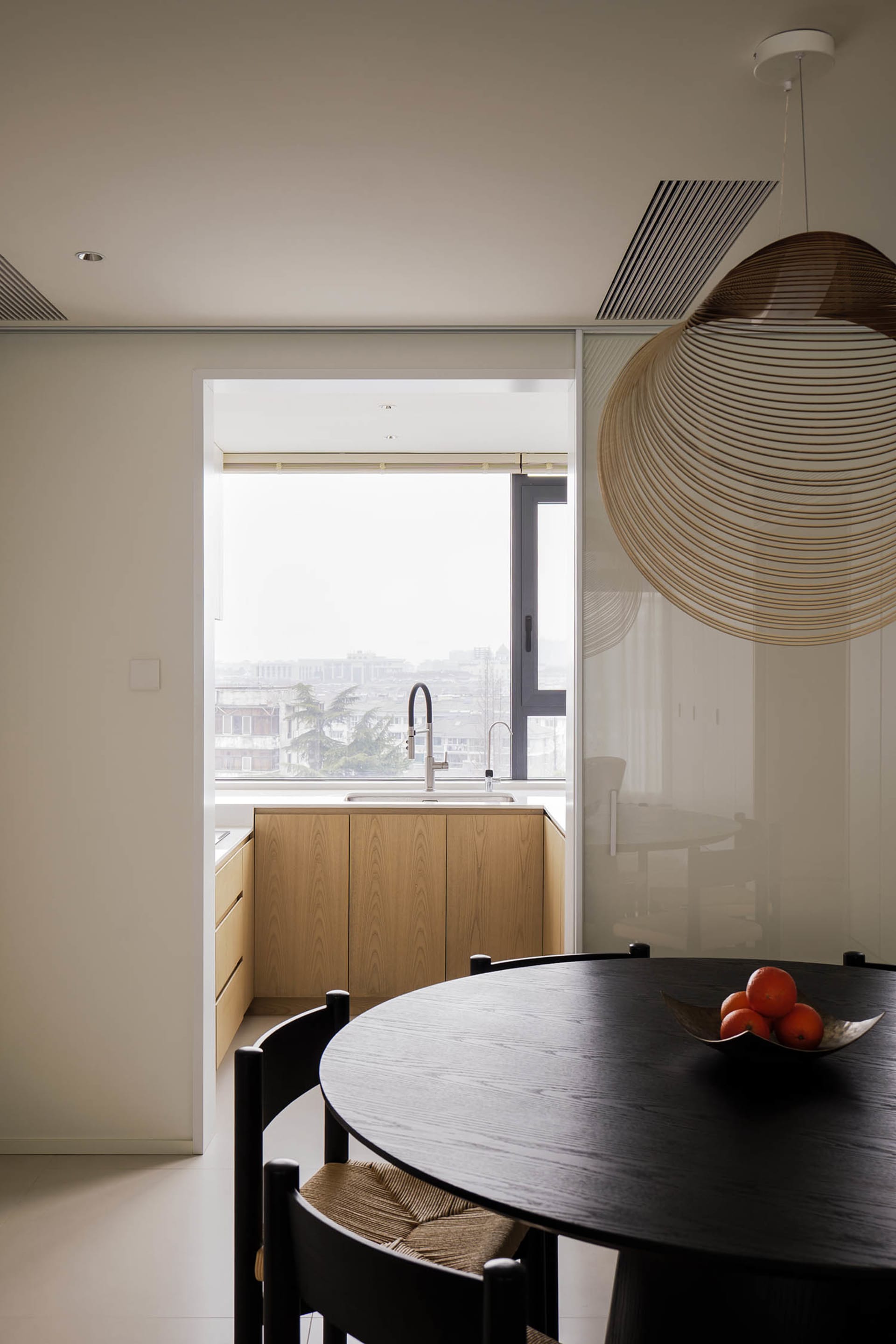 A modern residential kitchen featuring wooden cabinetry and a glass backsplash.