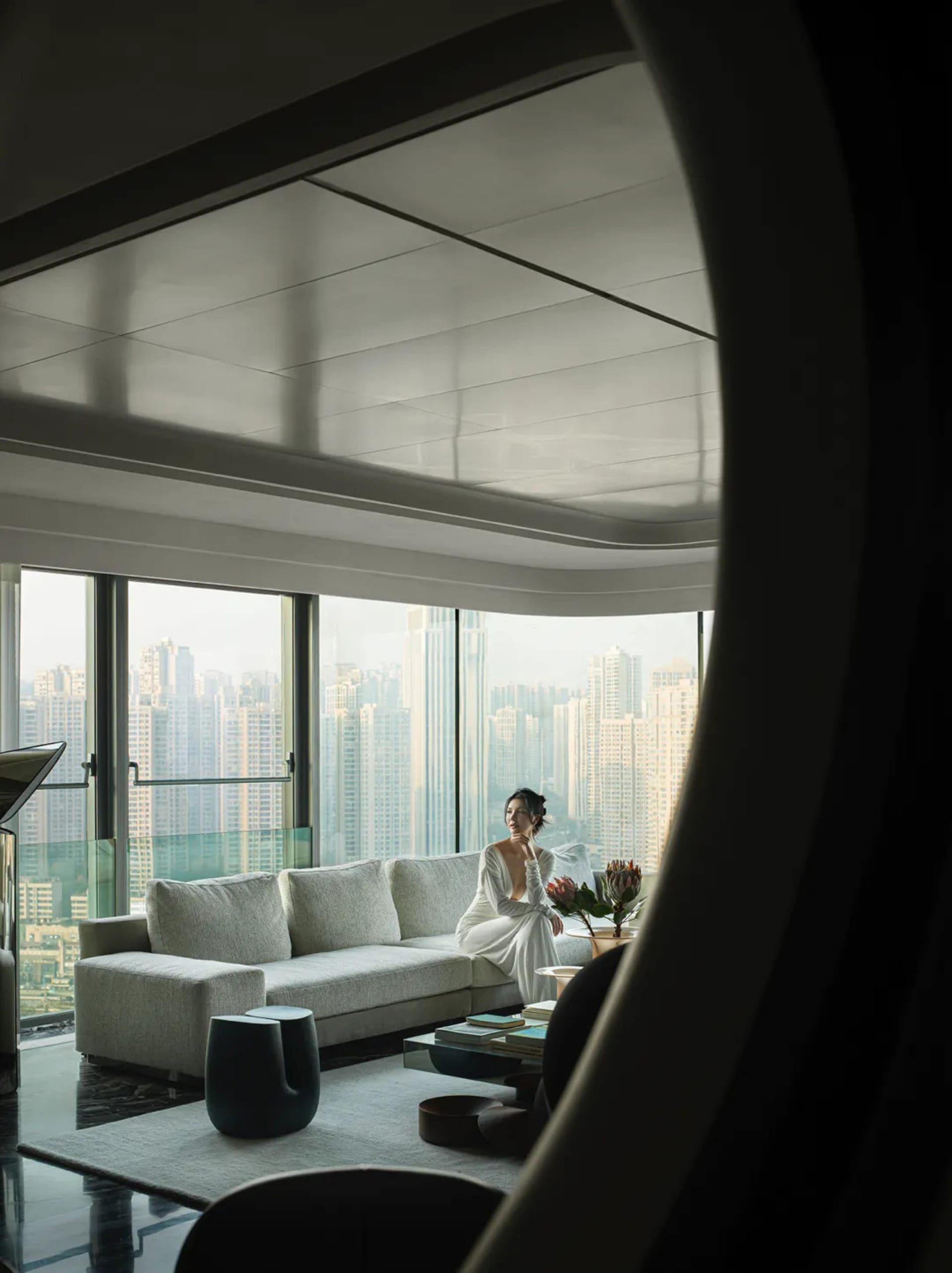 A modern living room with large windows overlooking a cityscape.