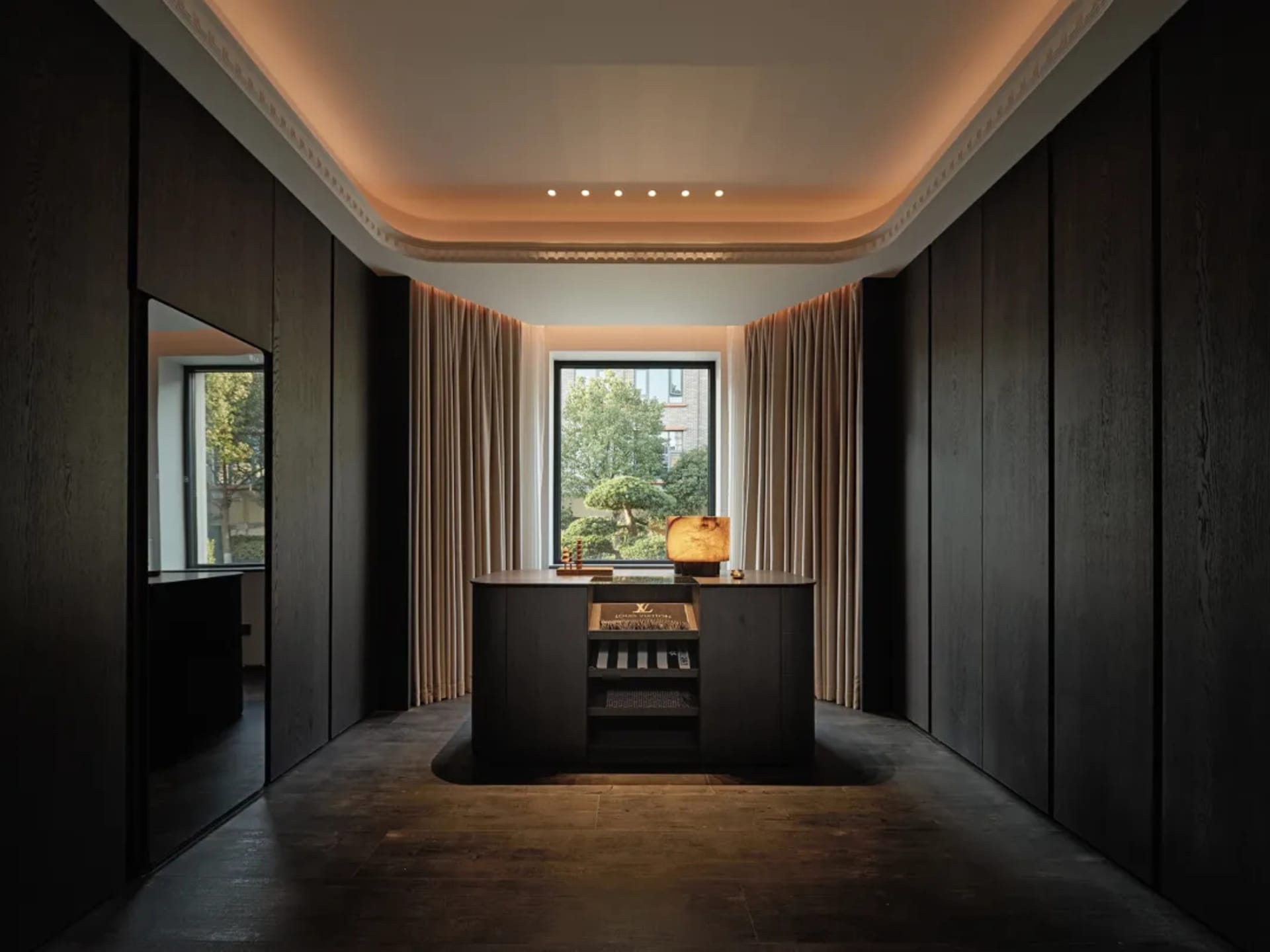 A modern office desk space with dark wooden cabinets and a central desk.