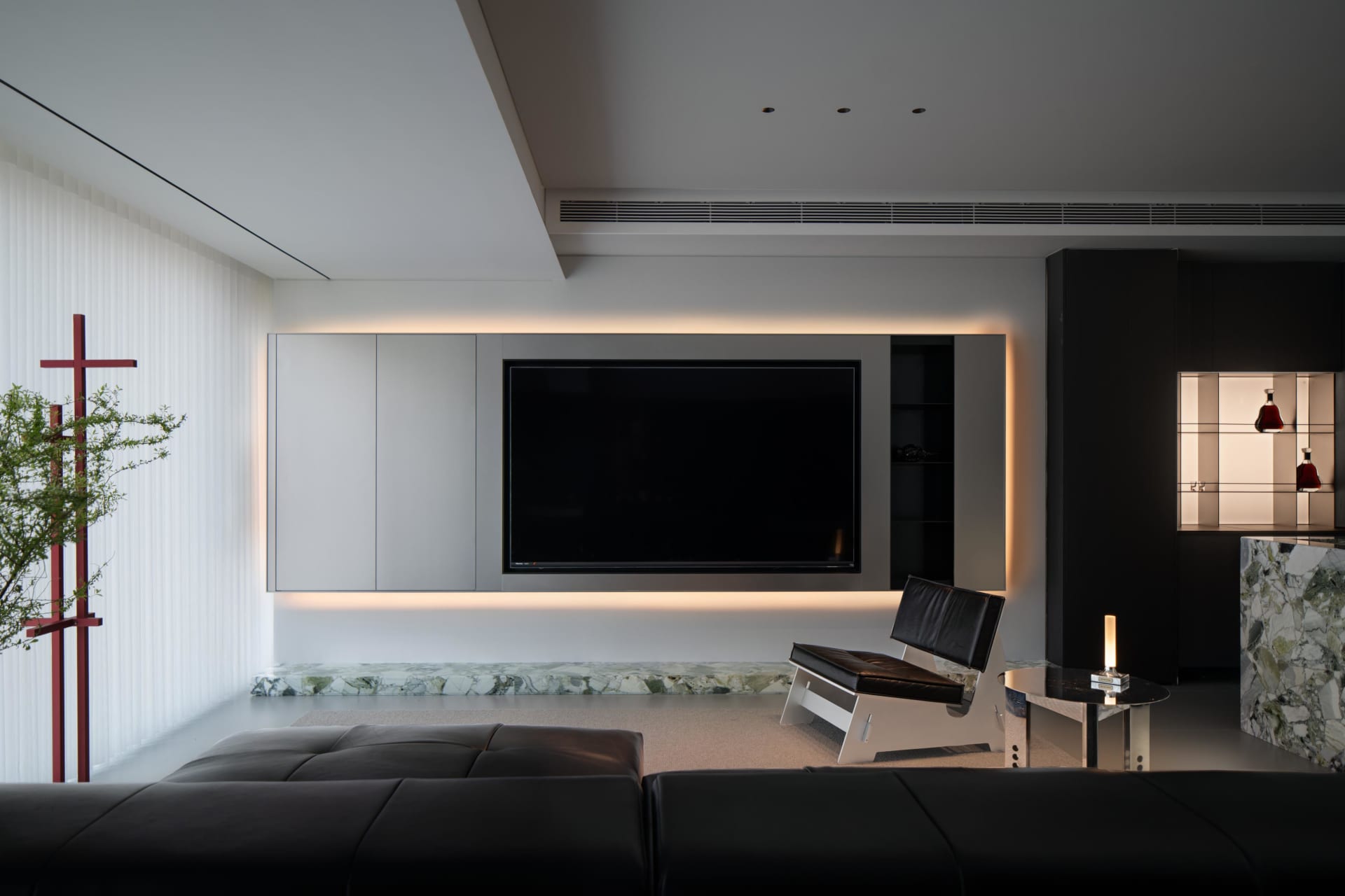 A minimalist living room featuring white marble floors and black steel furniture.