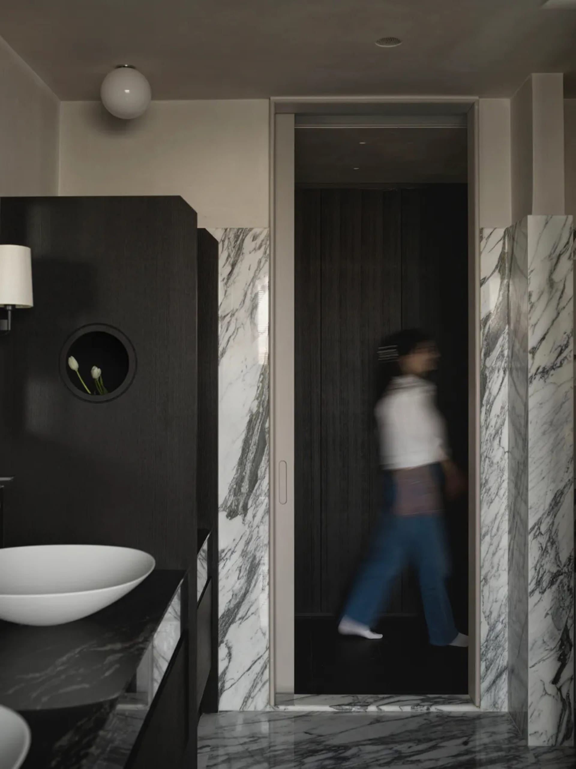 A modern bathroom with marble walls and wooden elements