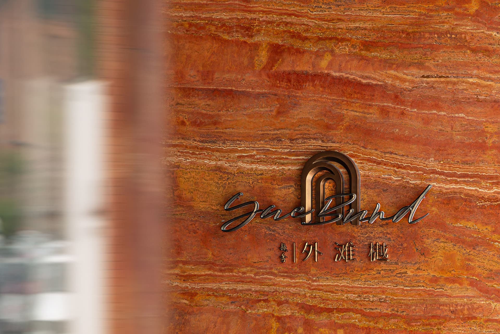 A modern interior design feature with a metallic emblem mounted on a slate surface.