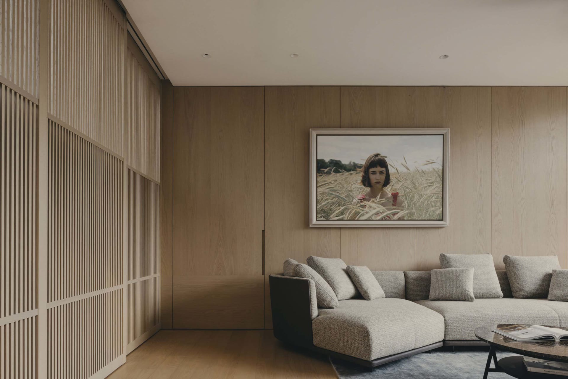 A modern living room featuring wood-paneled walls and a comfortable sectional sofa.