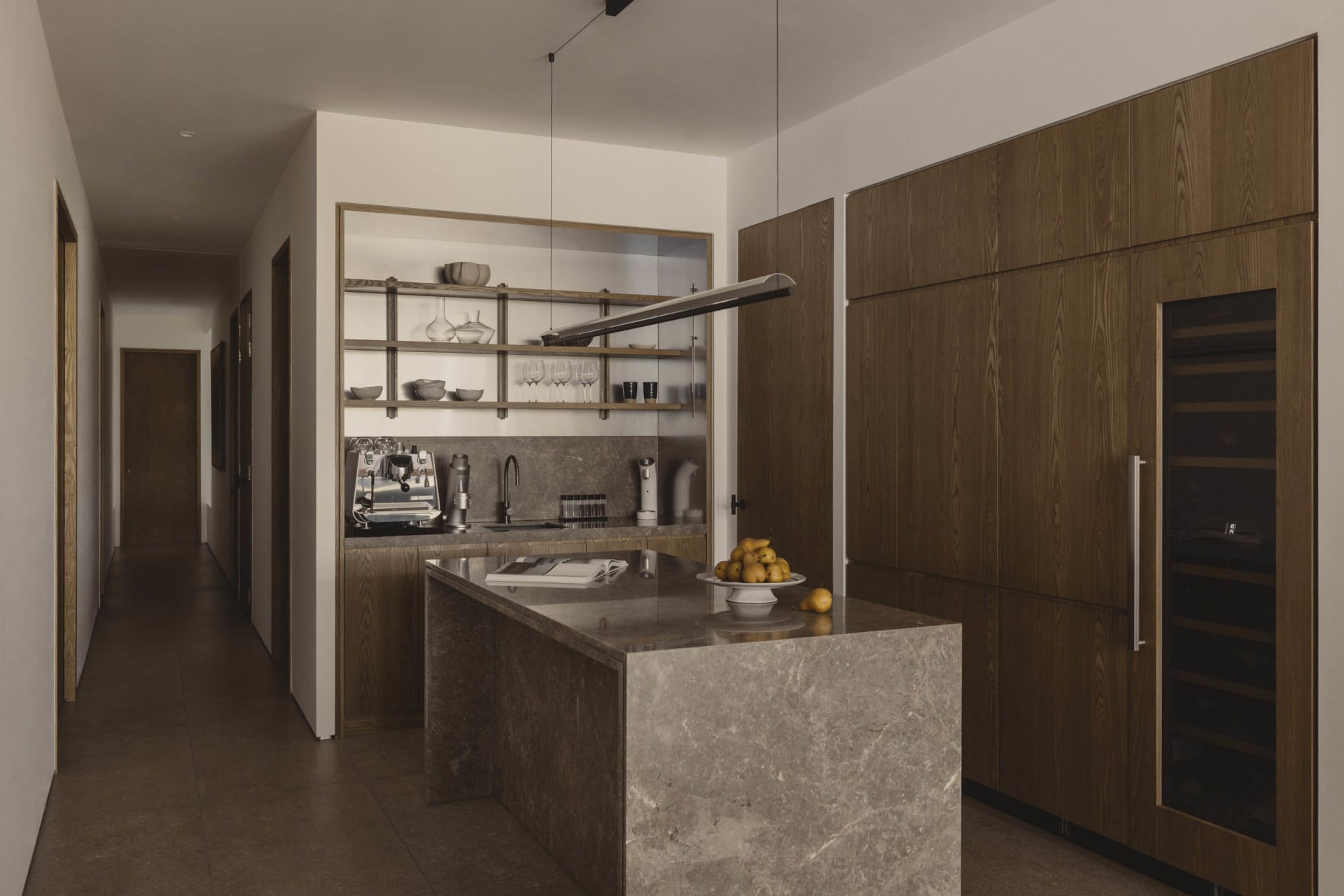 Modern kitchen featuring marble countertops, steel appliances, and wooden cabinetry