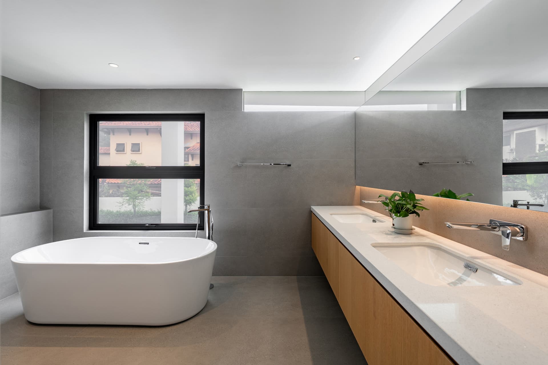 Modern bathroom with concrete walls and a large freestanding bathtub.