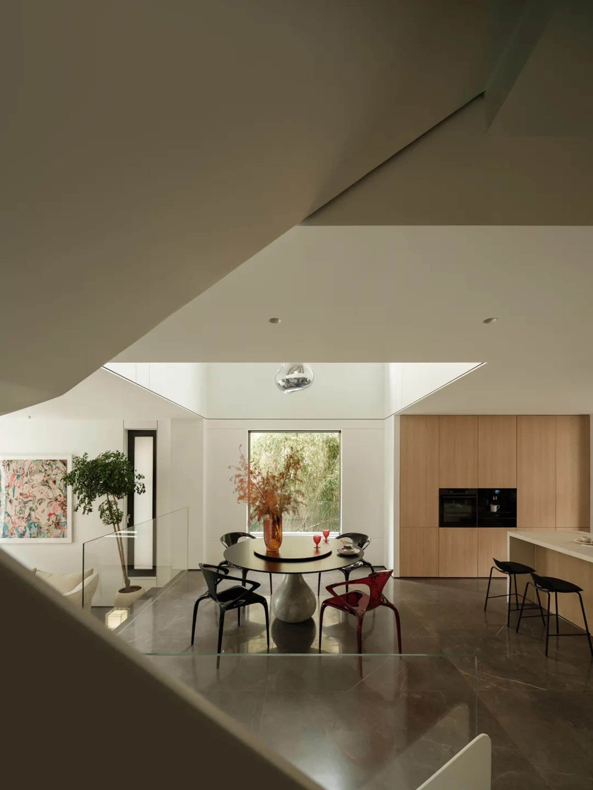 A modern kitchen with marble countertops, glass decor, and botanical elements.