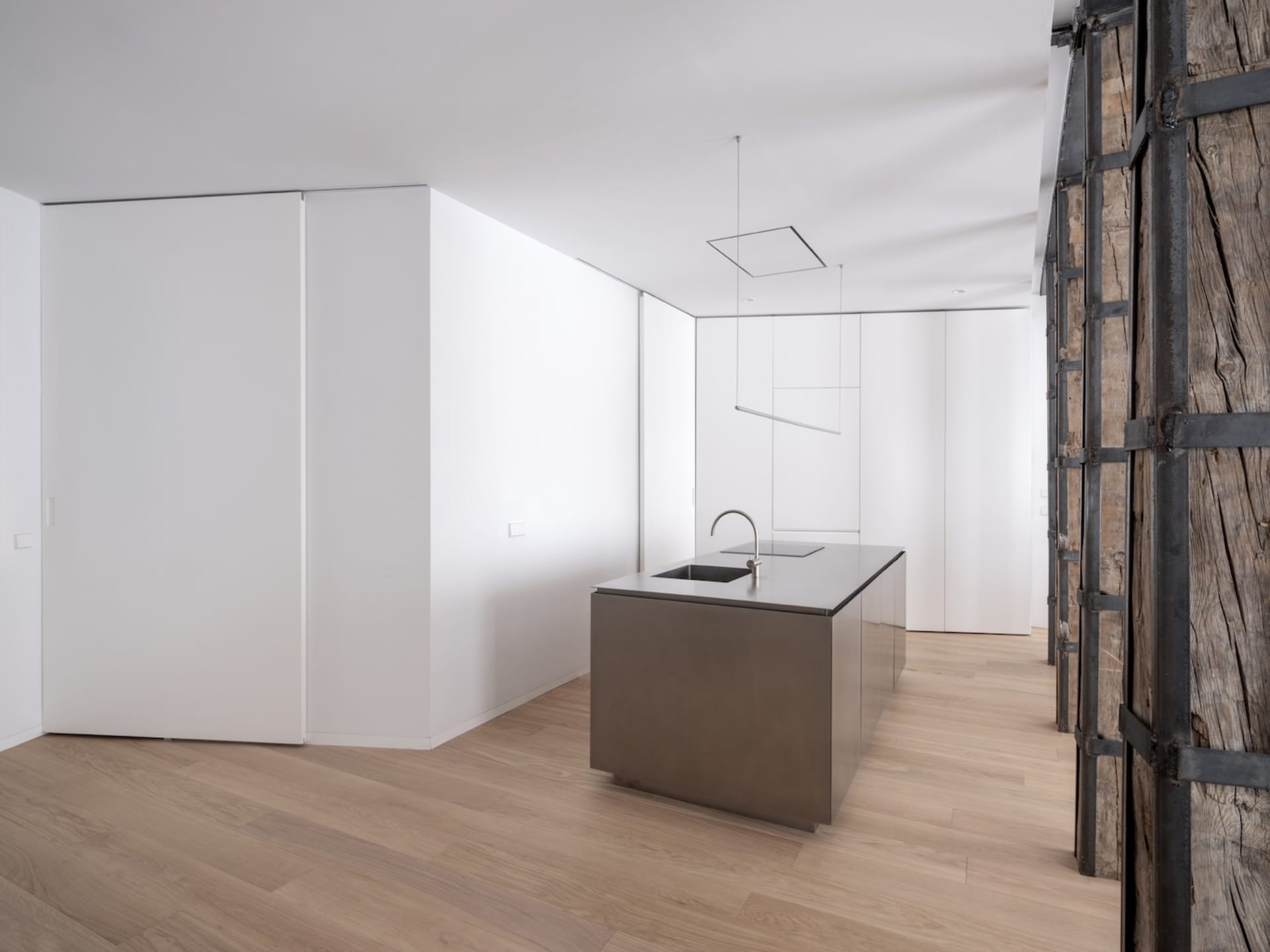 A modern kitchen featuring a minimalist design with a steel countertop.
