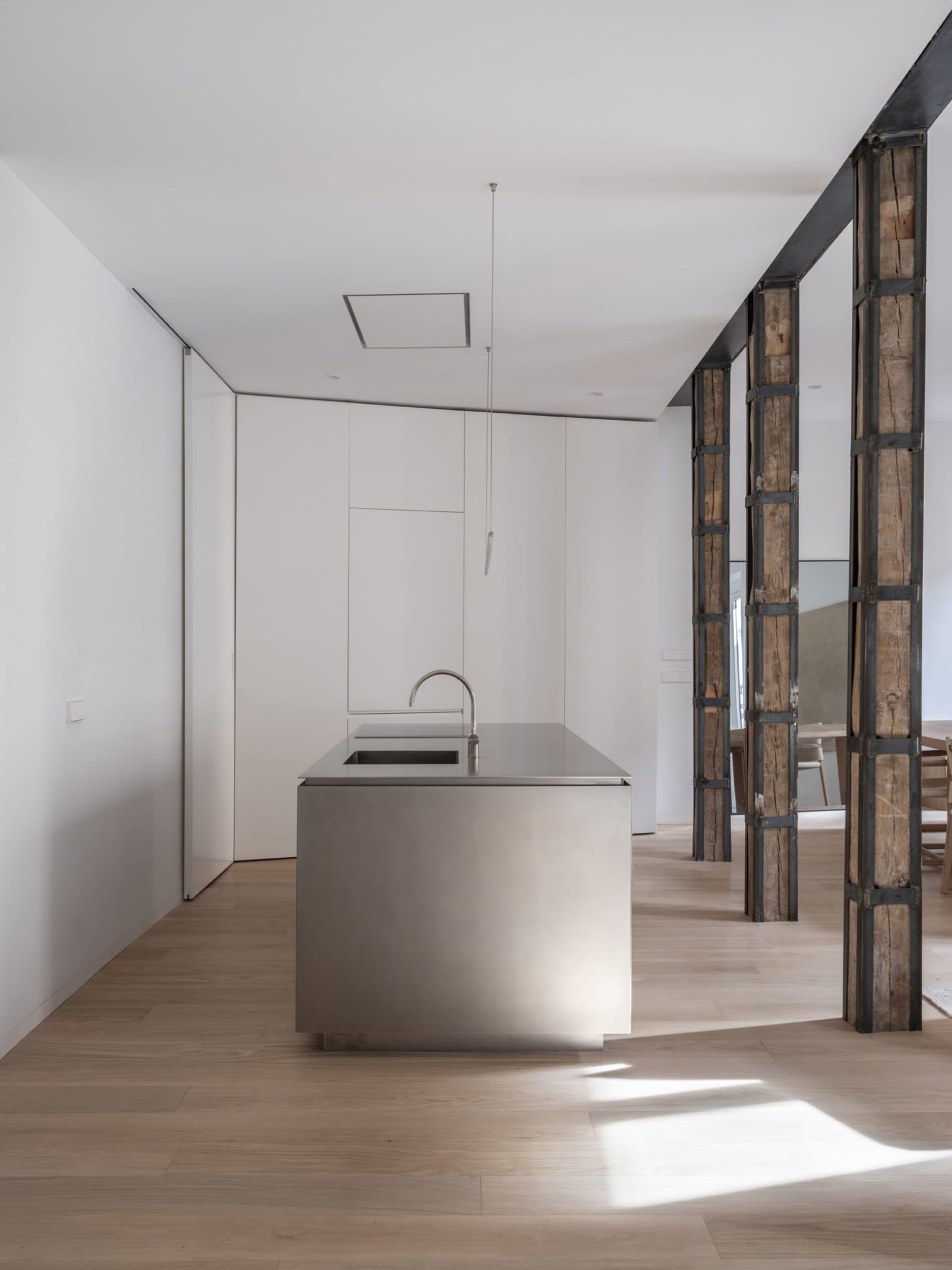 Modern, minimalist kitchen with a metal island.