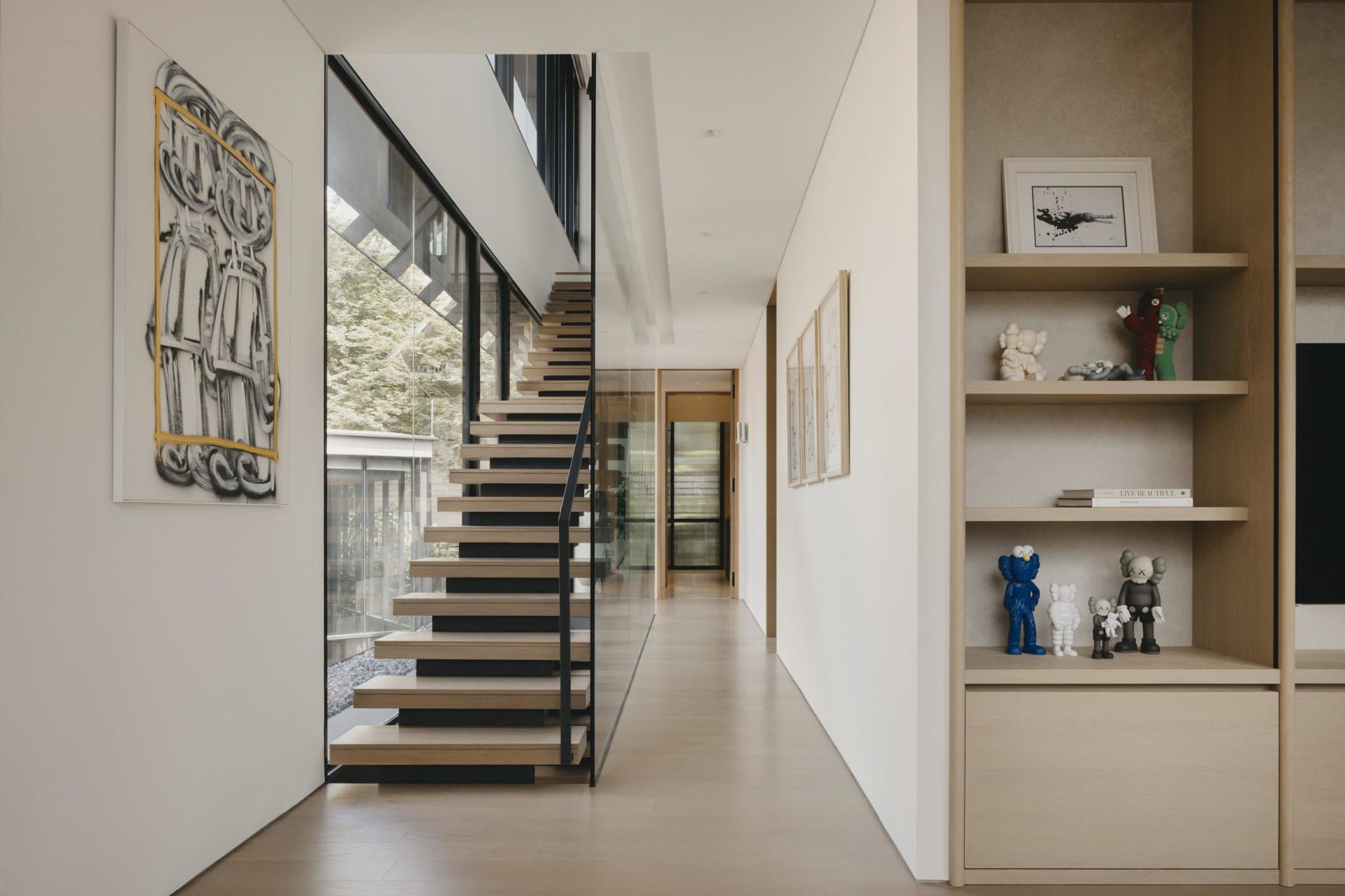 Modern residential entrance featuring timber stairs and white walls.
