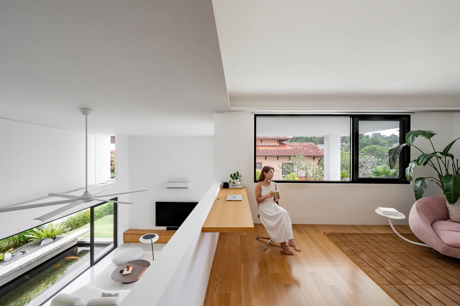 A modern interior living room featuring white walls, wooden flooring, and glass elements.